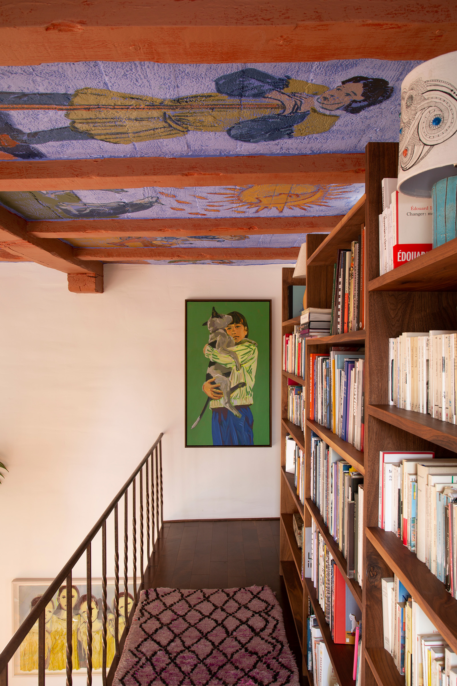 Claire Tabouret's hand-painted tarot ceiling and a 2020 self-portrait with the family dog adorn the mezzanine library of her Hollywood home