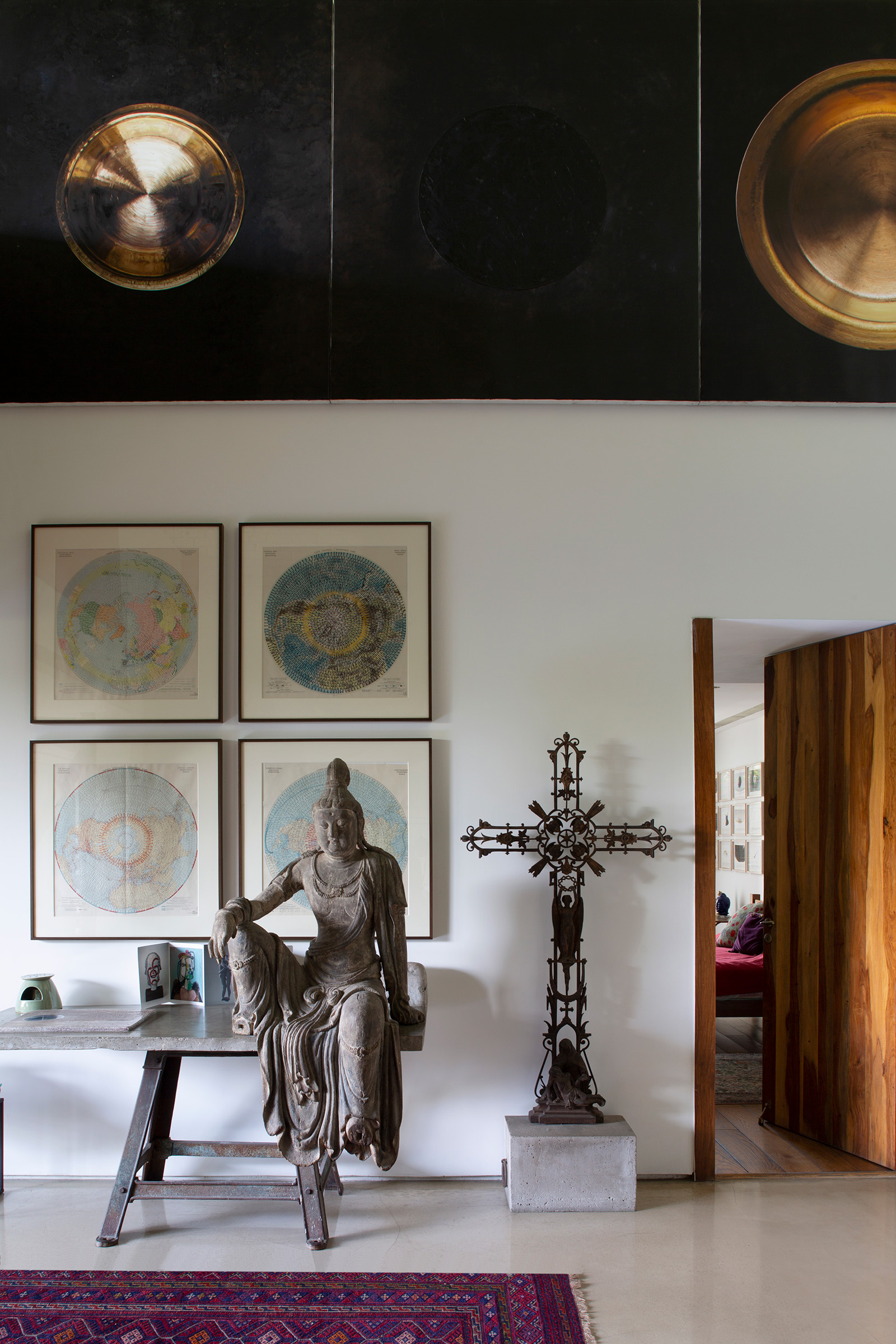 A gilded wooden Bodhisattva Guanyin and a cast-iron cross from a French flea market are among the objects found in the apartment of Subodh Gupta and and Bharti Kher, near New Dehli