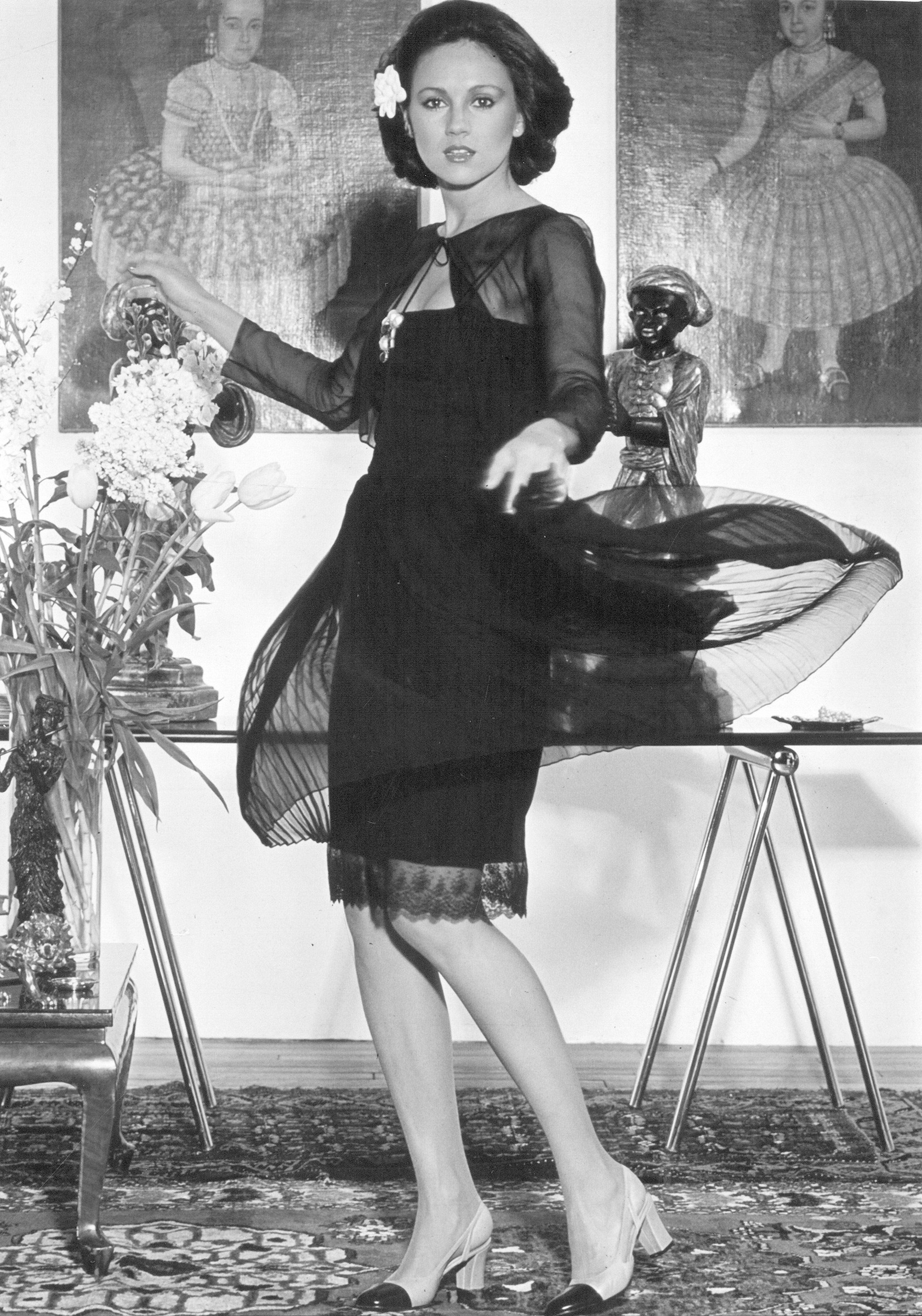 A short evening dress of black pleated silk chiffon with bootlace straps and a gauze jacket, 1960. A very similar dress appears in Harper's Bazaar, Winter 1960-61, with the text: 'Chanel, although still out on her own, has accepted the new feeling and comes into line with her limp dark chiffon for little evenings - or in her own view, practically any evening, anywhere in the world' 