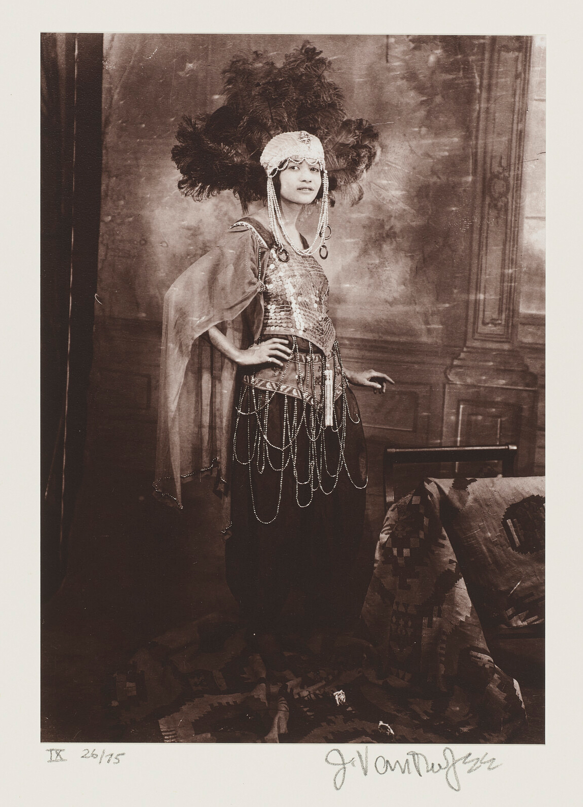 An elaborate costume with large feathered headpiece and layered chains