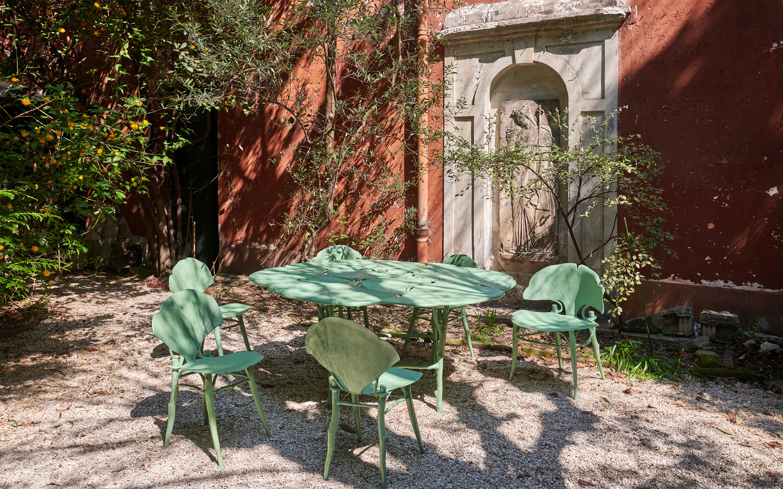 A Ginkgo Dining Table by Claude Lalanne, five from a set of six Ginkgo Chairs and one of a set of four Ginkgo Armchairs by the designer. All offered in The Collection of Baron Diego von Buch on 5 June 2025 at Christie’s in London. Photographed in the courtyard of the former Paris studios of the Russian-French sculptor Ossip Zadkine and the artists Helene and Claude Garache