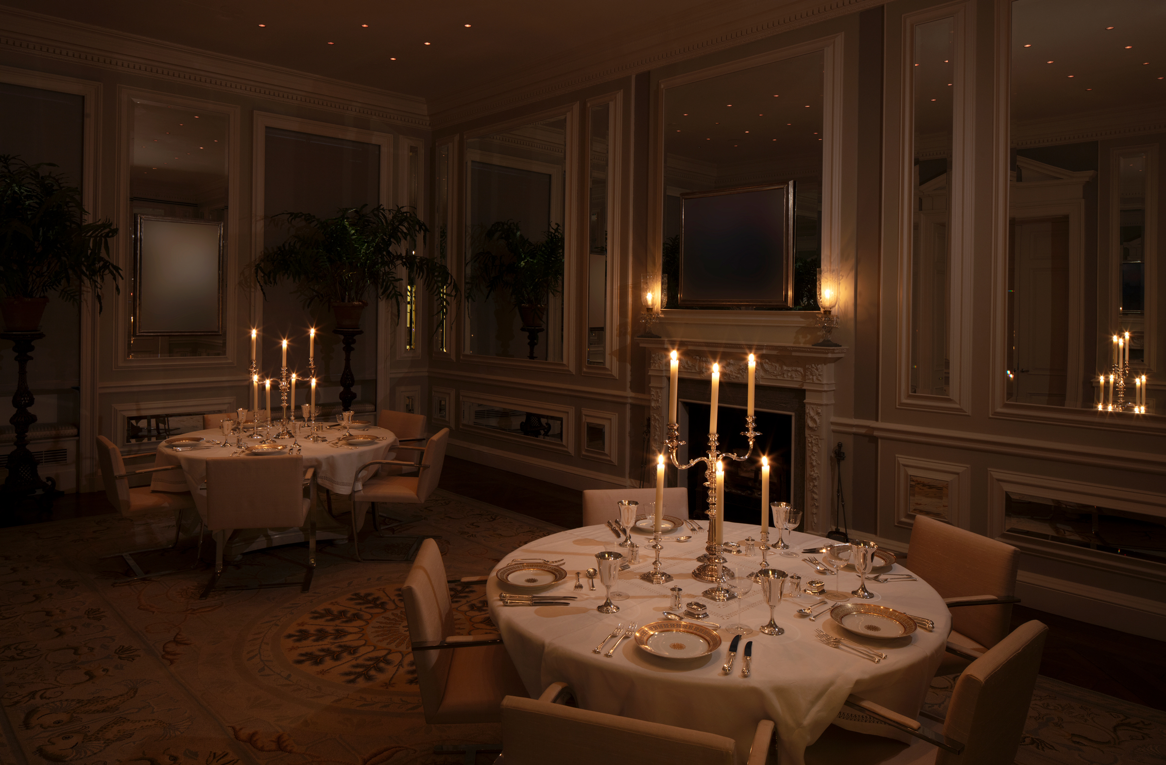 Elegant dining room with candlelit tables, classic decor, and ambient lighting.