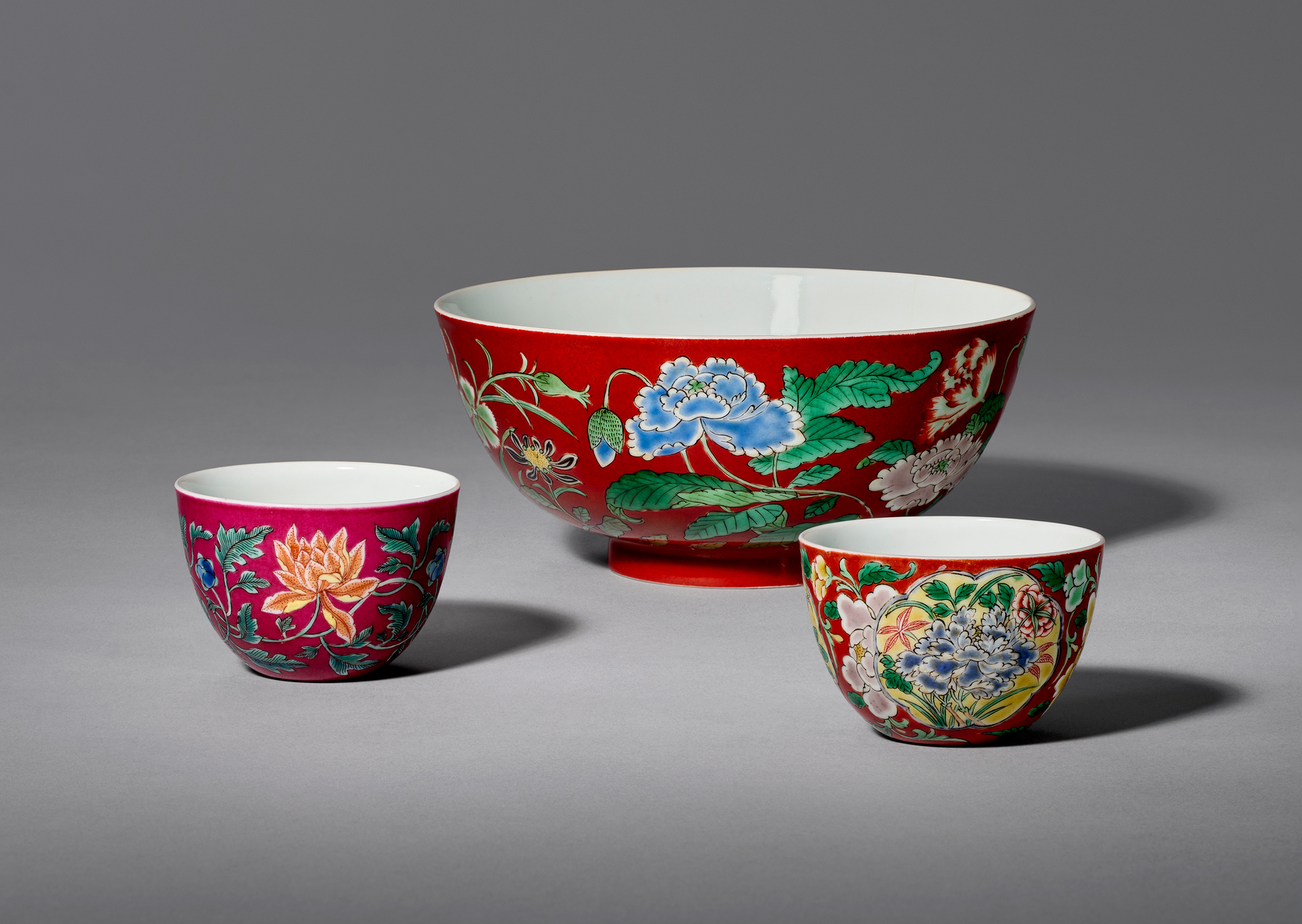 From left to right: An exceptionally rare imperial ruby red-ground falangcai ‘Indian lotus’ wine cup. 2½ in (6.4 cm) diameter. Estimate: $300,000–500,000; A very rare imperial coral-ground falangcai ‘floral’ bowl. 5⅞ in (15 cm) diameter. Estimate: $70,000–90,000; An exceptionally rare imperial coral-ground falangcai ‘floral’ wine cup. 2½ in (6.4 cm) diameter. Estimate: $300,000–500,000. All with Yongzheng four-character yuzhi mark in underglaze blue within a double square and of the period (1723–1735). Offered in Important Chinese Furniture and Works of Art of art on 18 September 2025 at Christie’s in New York