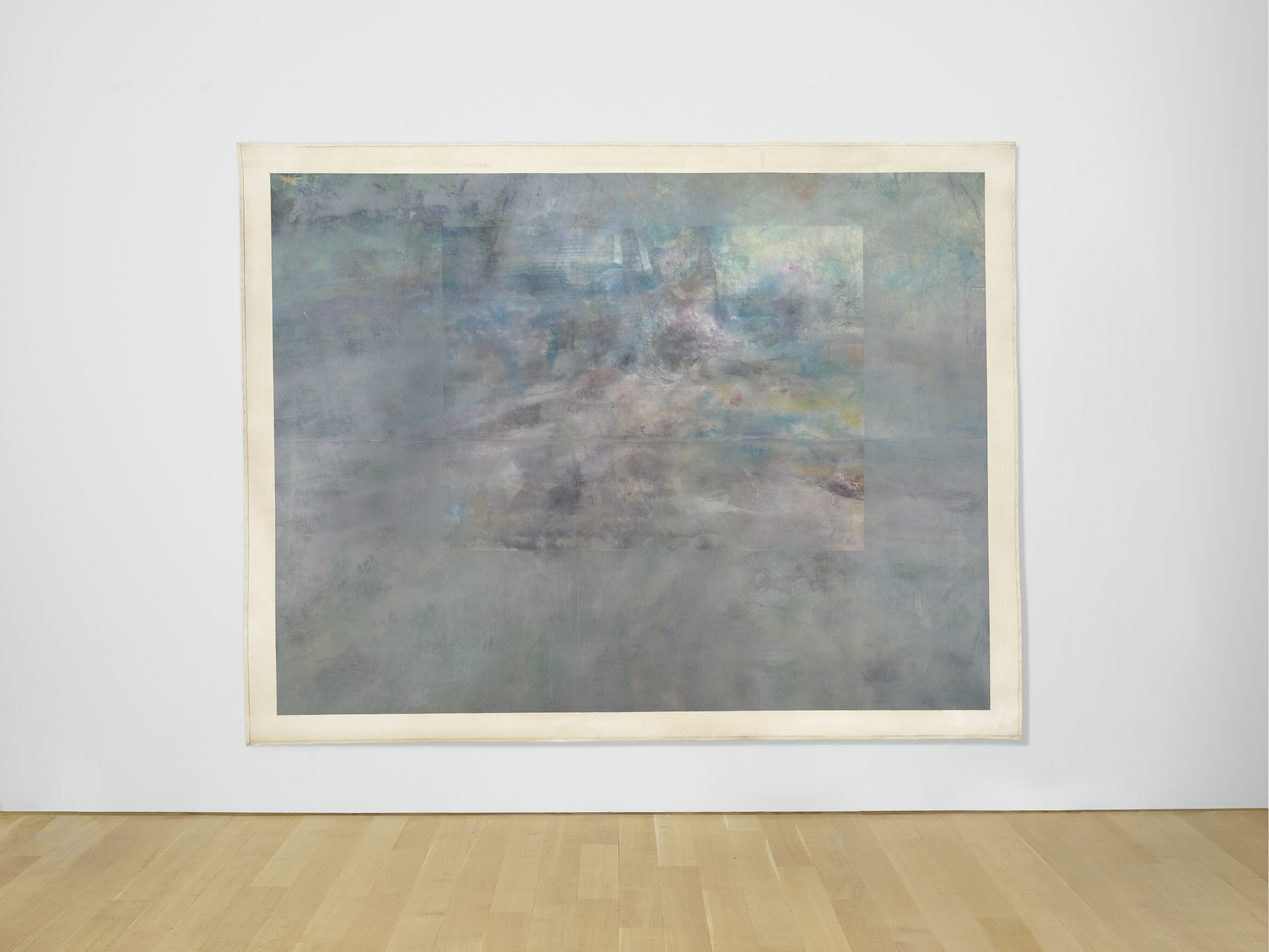 A large, abstract painting with muted, flowing colors displayed on a white wall in an art gallery.