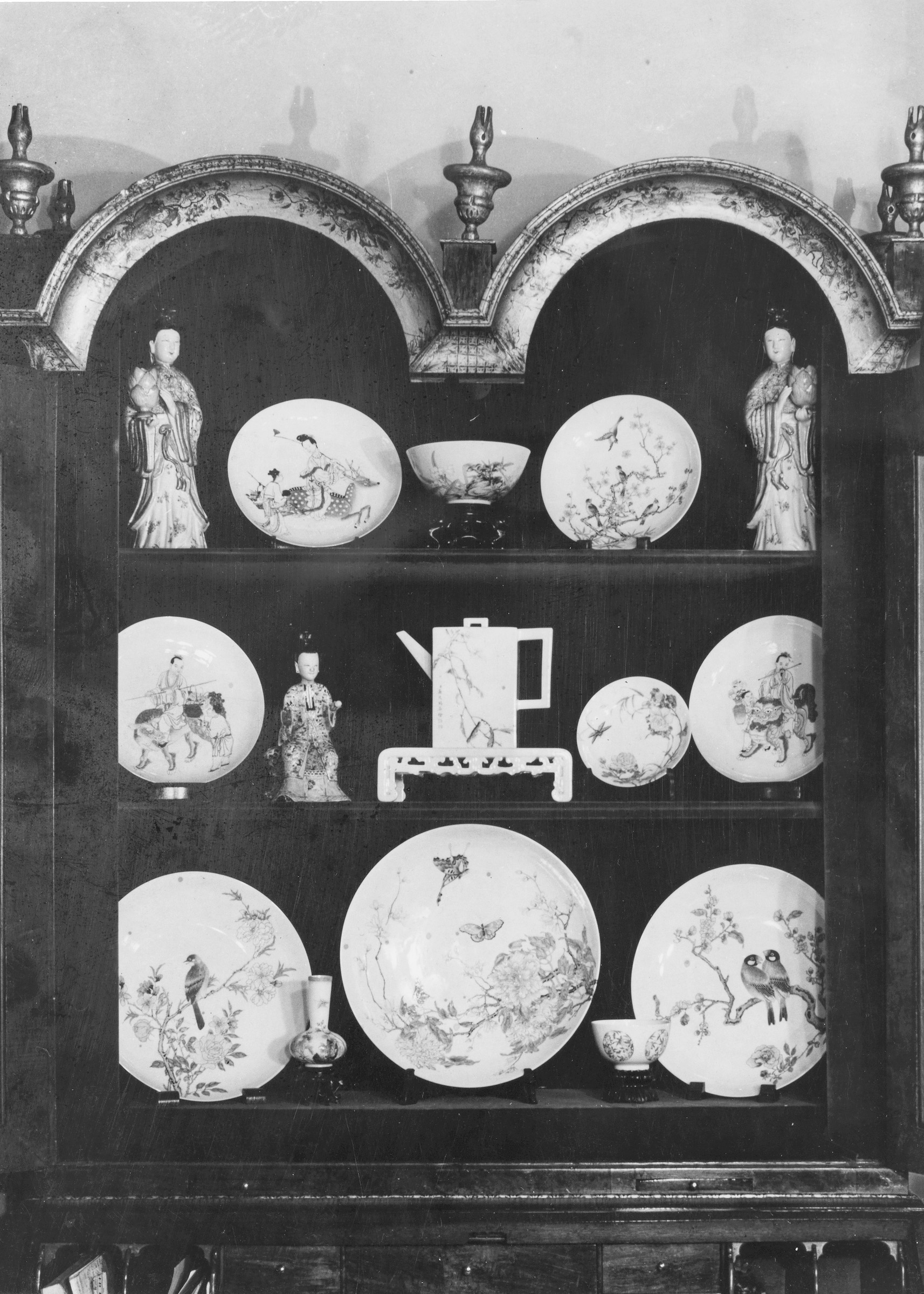 Lot 20 from the sale, a famille rose flowers and birds dish (top right corner), in the porcelain display cabinet at the Palmer family home, Hurst Grove, near Reading