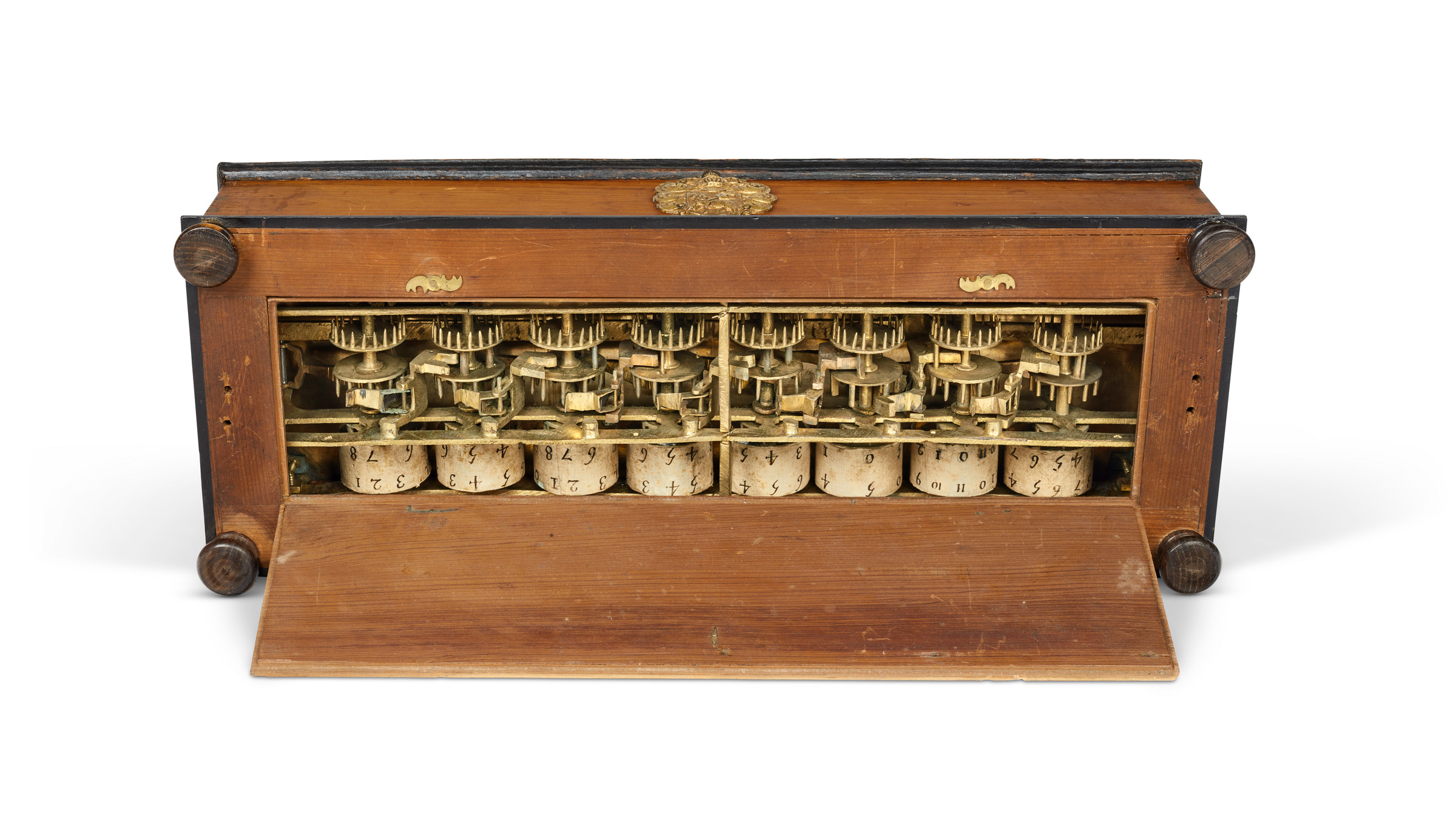 The Pascaline is regarded as the foundation of mechanised calculation. Opening a panel in its base allows a view of the complex series of wheels, gears and springs with which it operates, and the spools of numbered paper that display the results