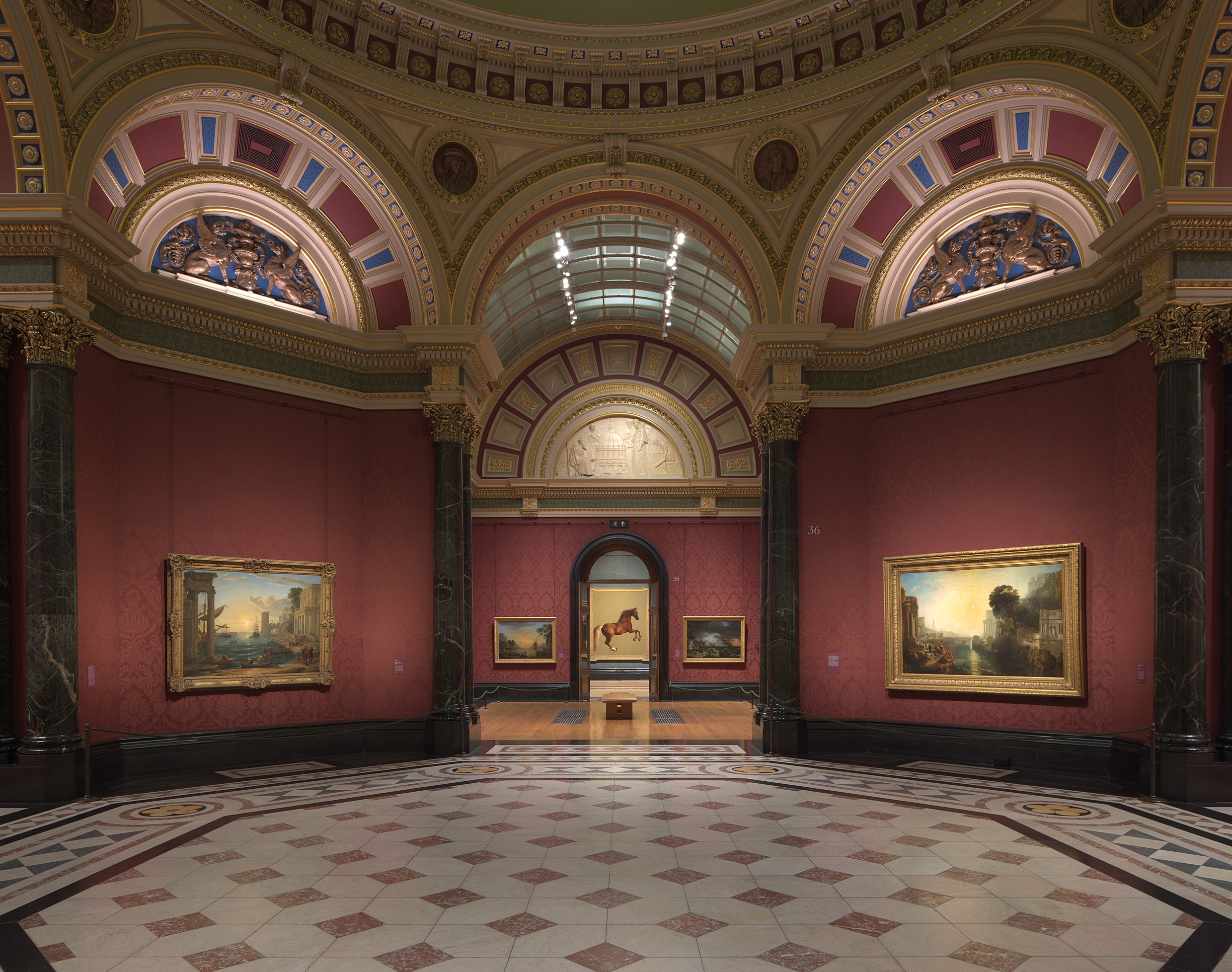 The National Gallery in London, showing in the foreground (left) Seaport with the Embarkation of the Queen of Sheba, 1648, by Claude. On the right is Turner's Dido building Carthage, 1815, part of the 1856 Turner Bequest