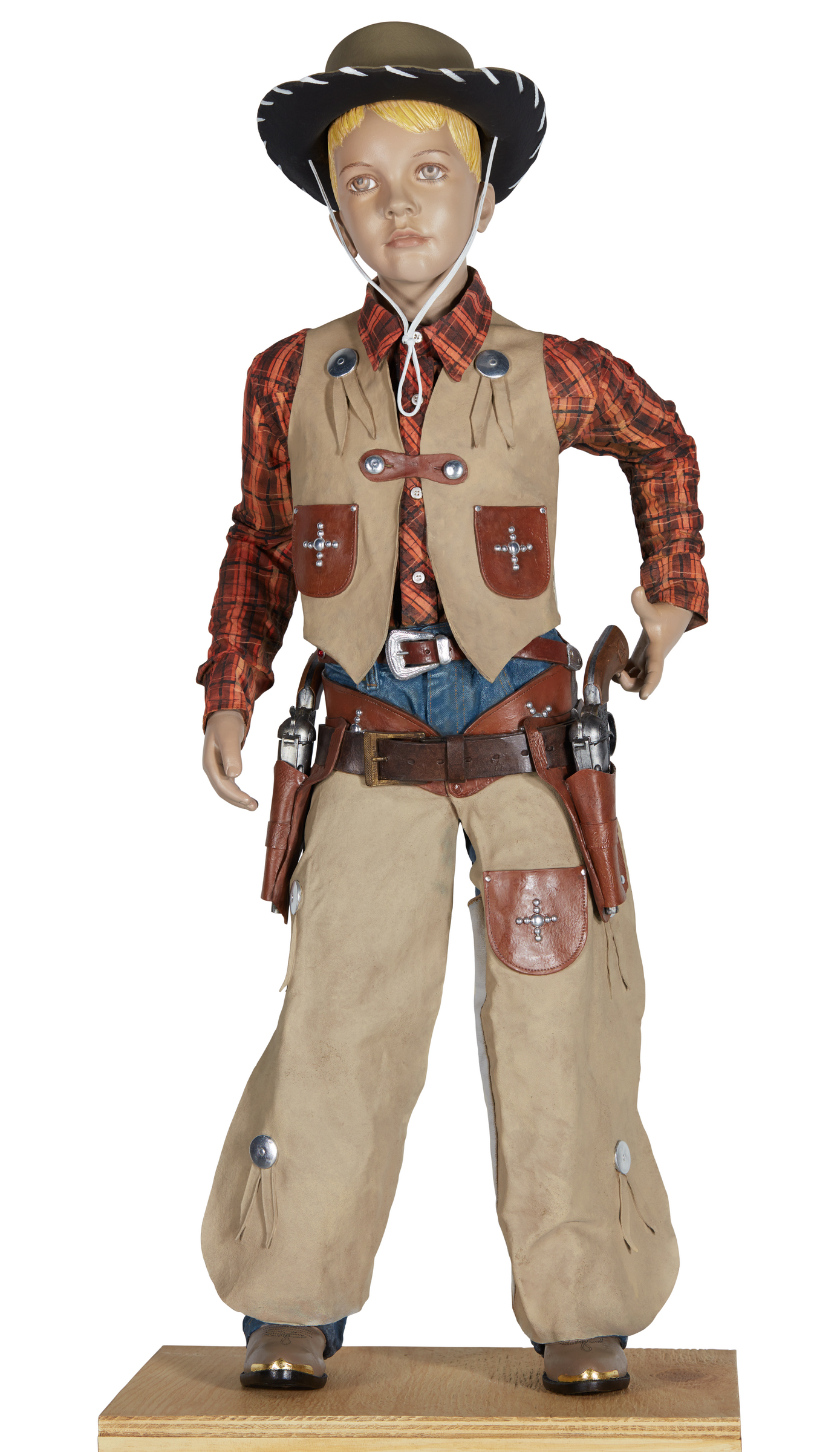 This is a mannequin dressed in an Old West cowboy outfit, including a plaid shirt, leather vest, chaps, and accessories like a gun holster.