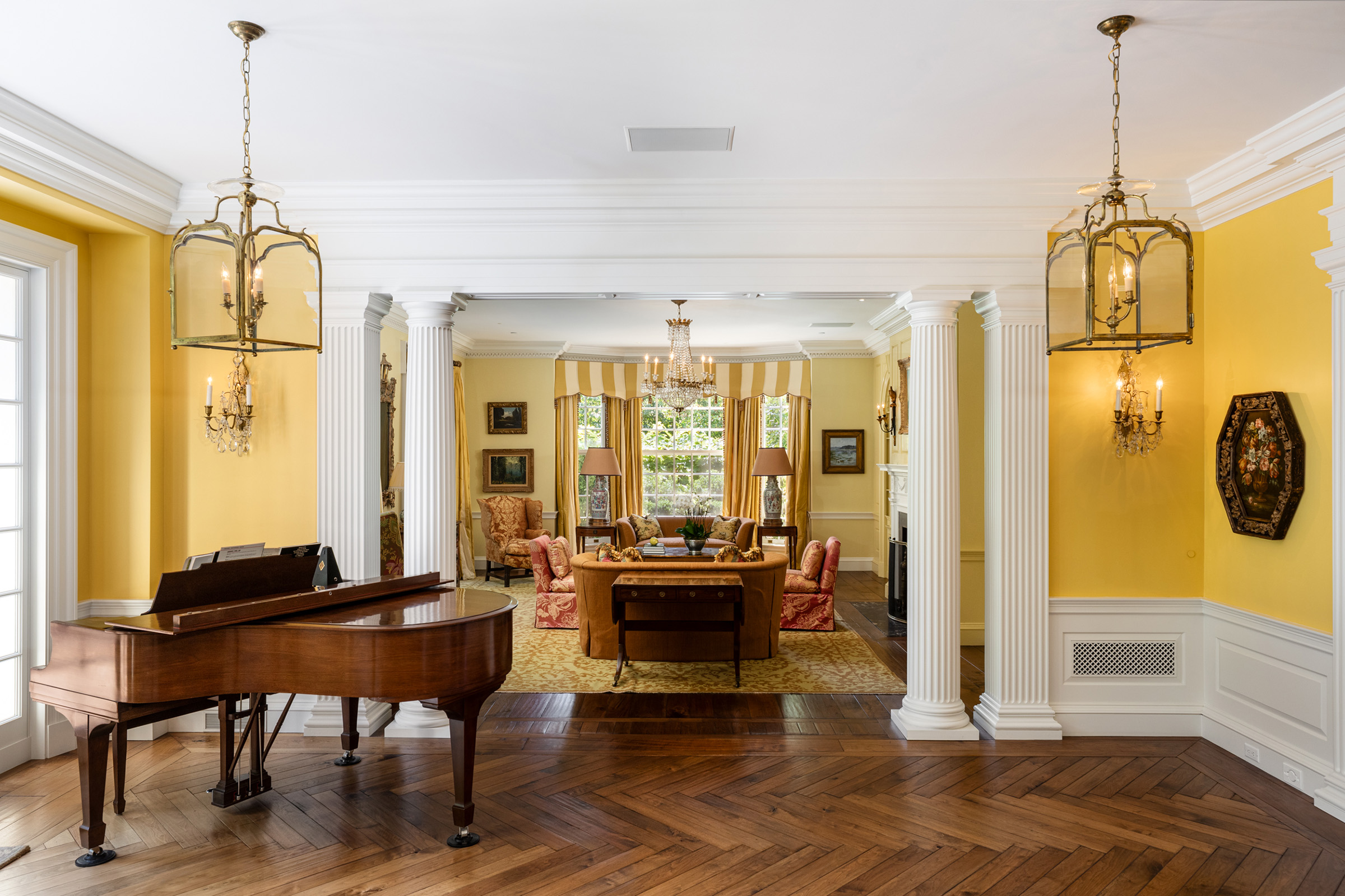 A view of one of the reception rooms, where key design features include walnut floors and elegant fluted columns. The property is available via Christie's International Real Estate