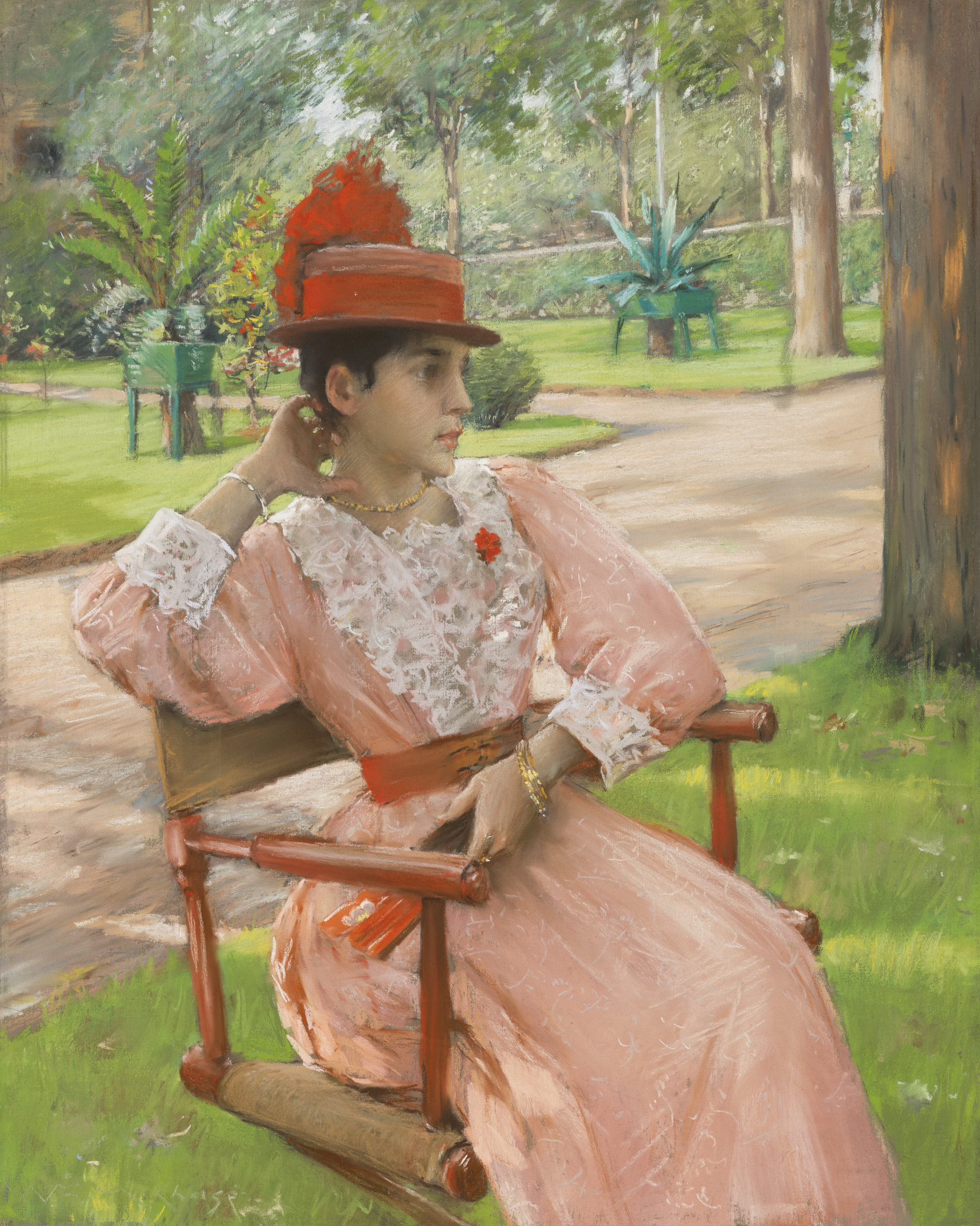 A woman in a pink lace dress and red hat sits on a wooden chair in a lush garden setting.