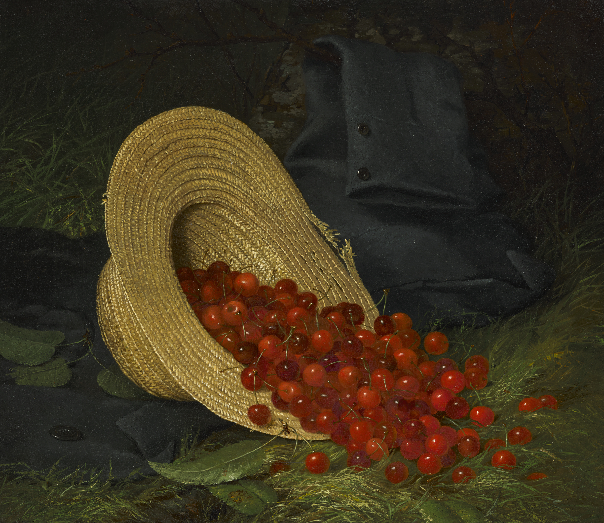 A straw hat is tipped over on the grass with red cherries spilling out beside a dark folded coat.