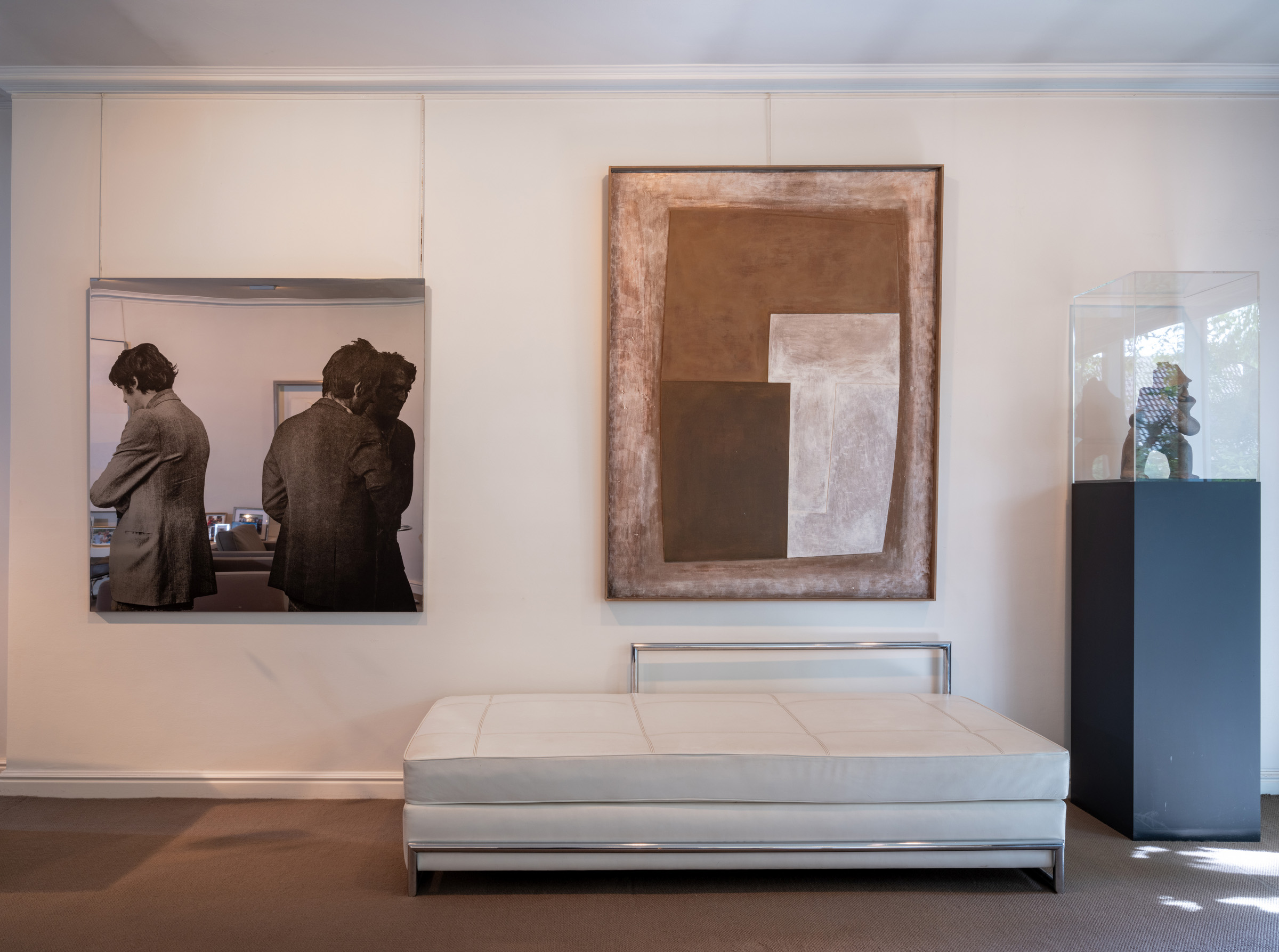 Michelangelo Pistoletto's mirror painting Tre Uomini in Grigio (Three Men in Grey) from 1974 hangs alongside Ben Nicholson's 1969 (green black), in oil on carved board