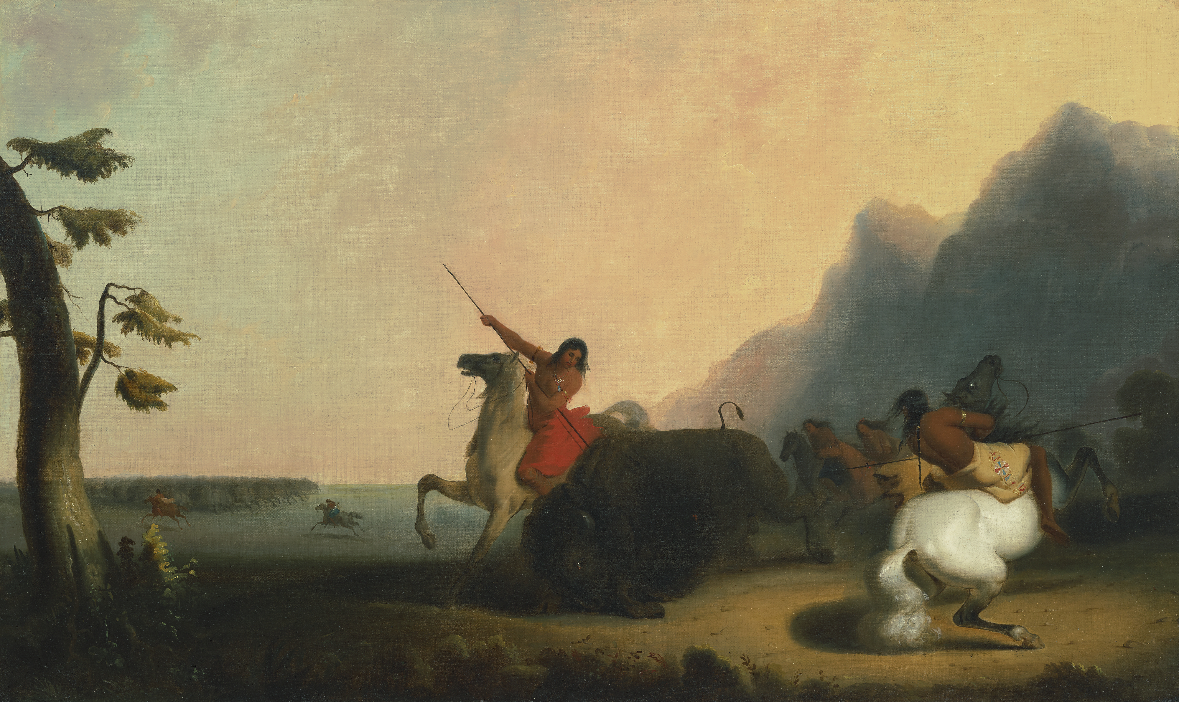 Several people on horseback are hunting bison on a vast plain near mountains at sunset.