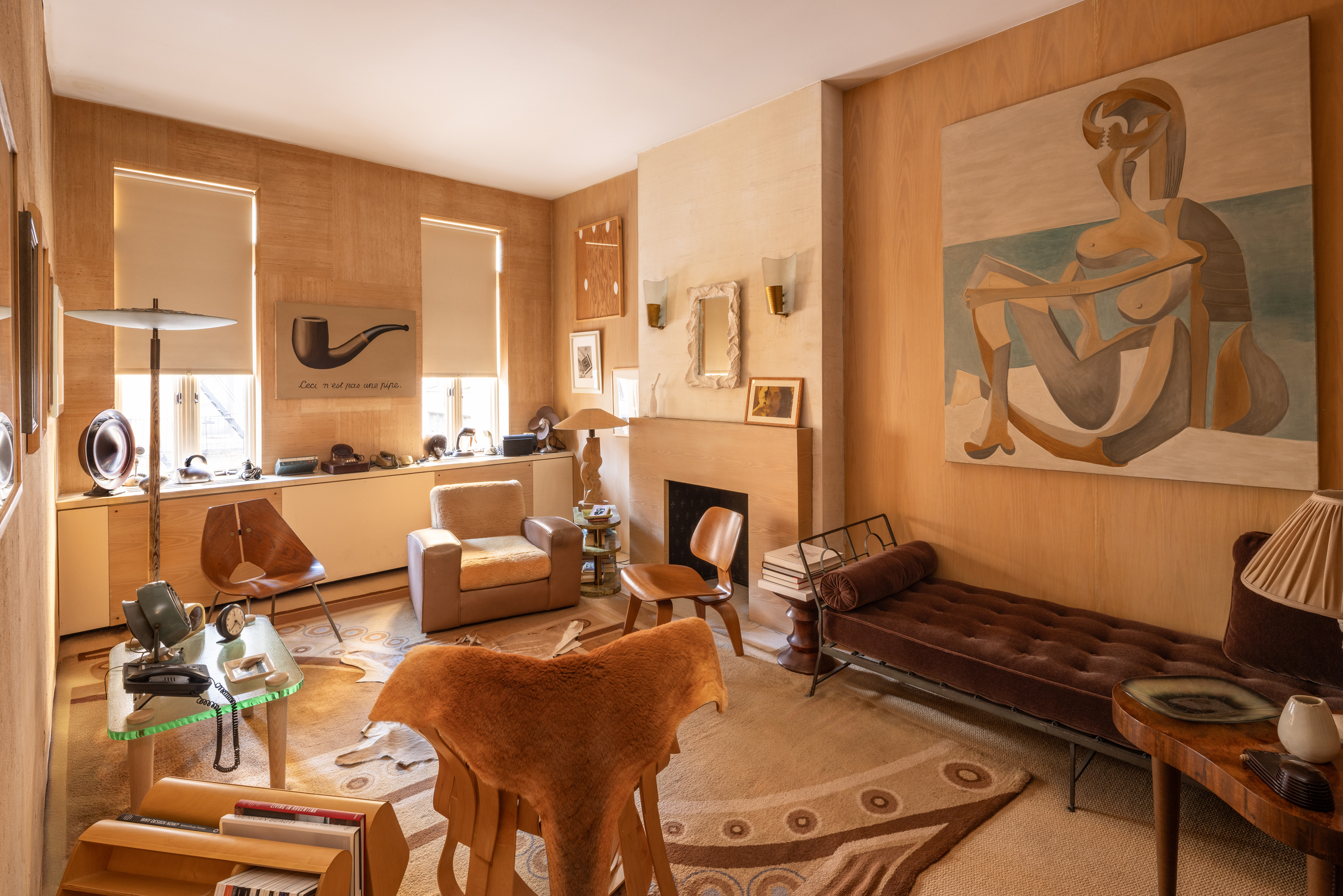 A cozy, artistic living room with modern furniture, abstract art, and warm brown tones.