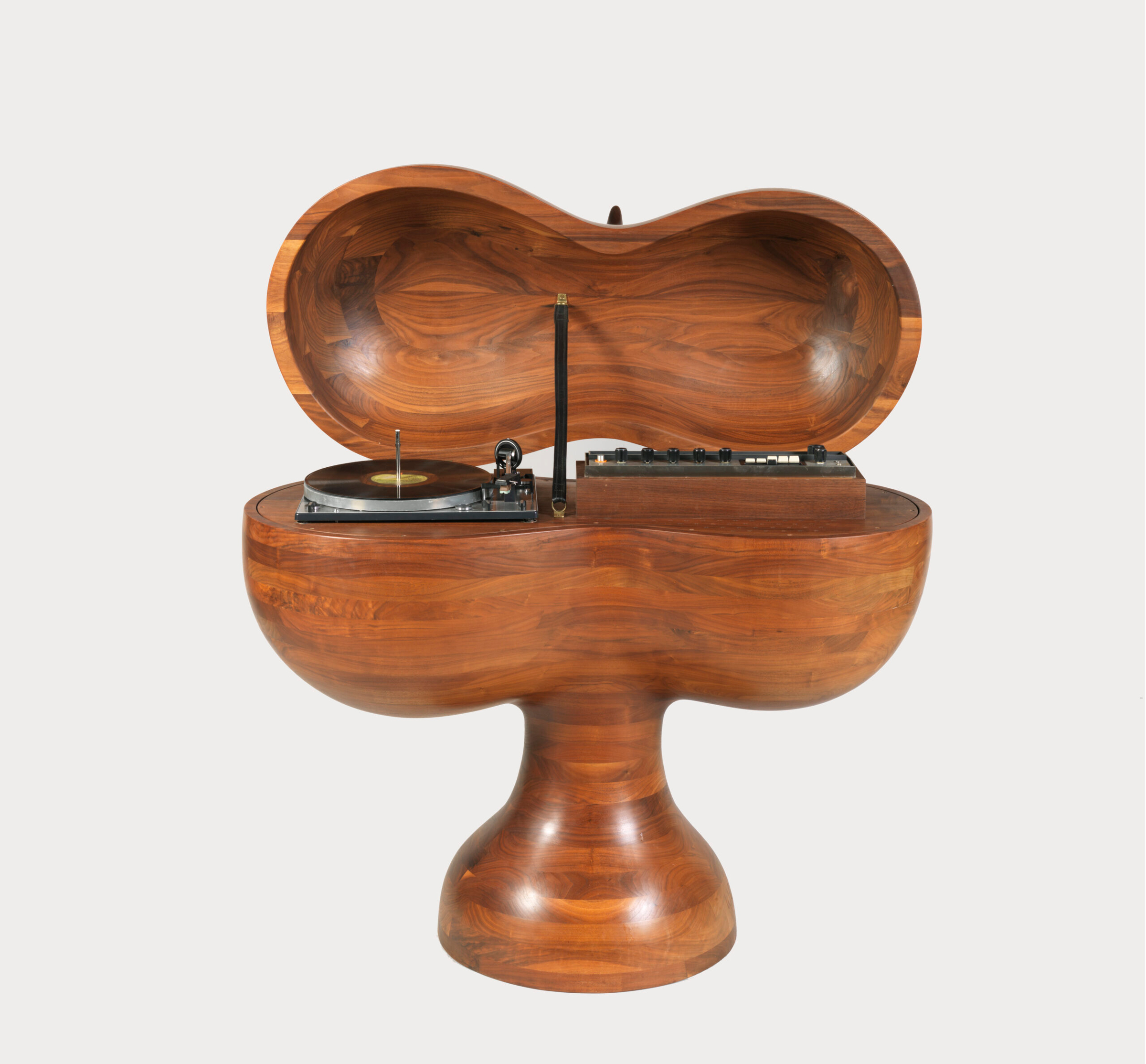 A wooden cabinet shaped like a mushroom contains a record player and audio equipment inside.