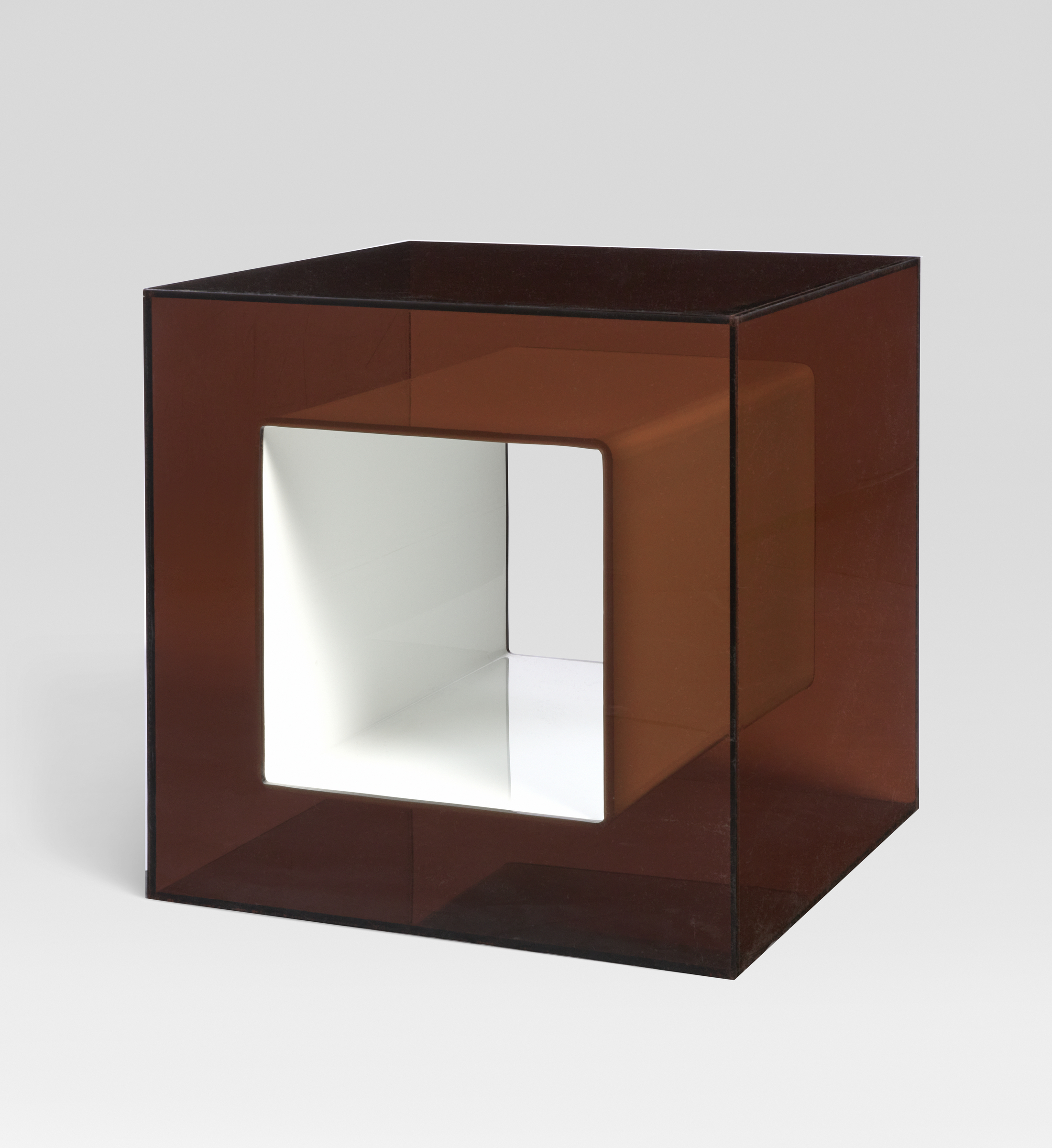 A translucent brown cube with a hollowed-out white inner cube at its center.
