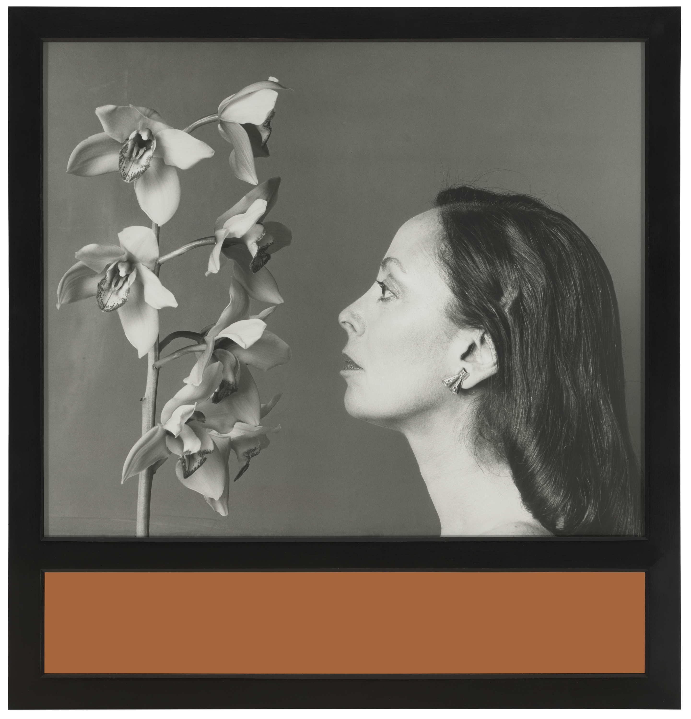 A black-and-white photograph shows orchids beside a person's head with long, dark hair.