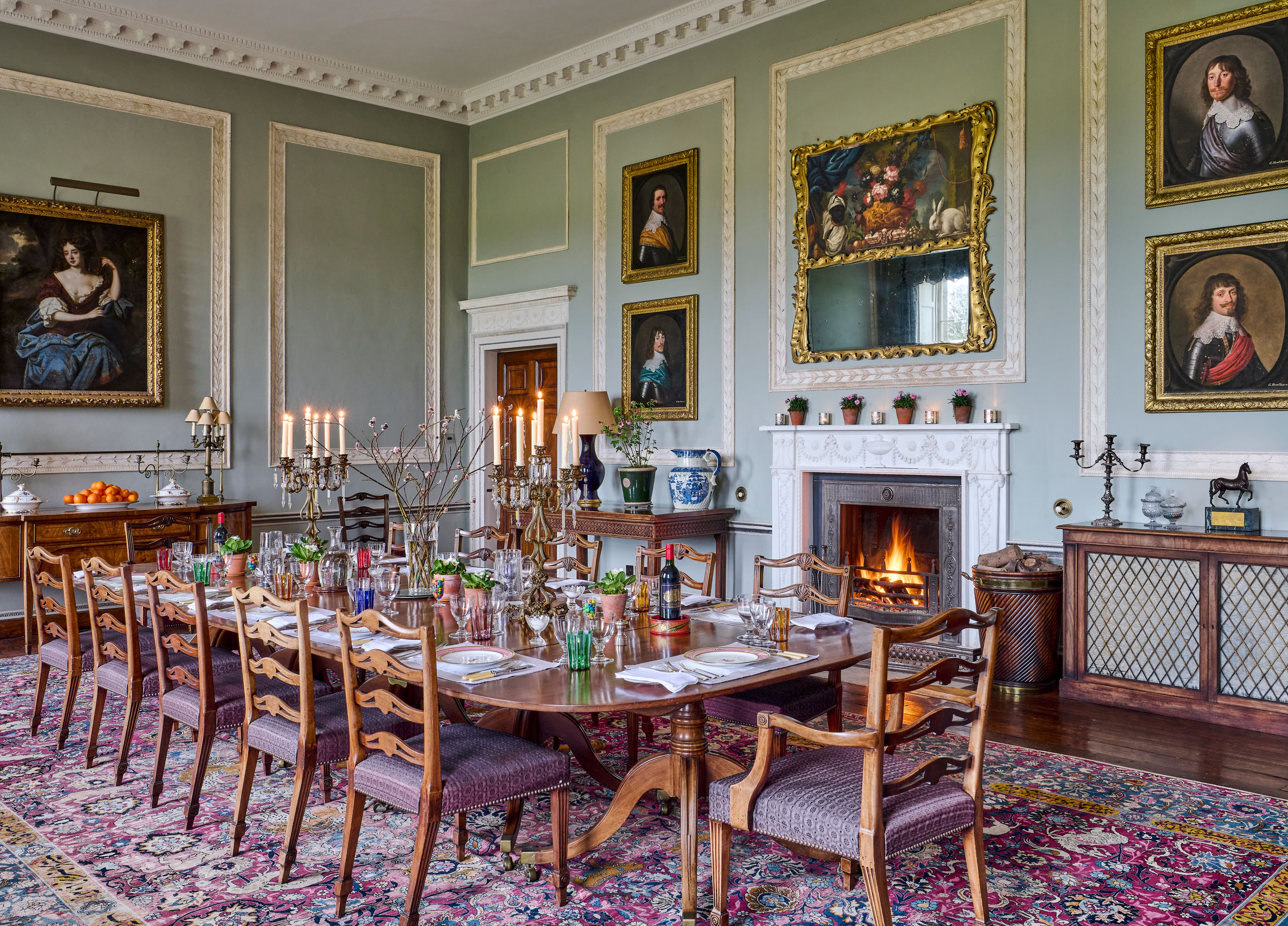 The Dining Room: a late George III Irish mahogany five-pedestal dining table; a set of 18 English mahogany dining chairs - six mid-18th century, attributed to Ince and Mayhew; 12 mid-19th century by Wright and Mansfield; a large Tabriz carpet, circa 1910. At the head of the table is Portrait of Jane Webb, née Smith (d. 1669), seated three-quarter-length, in a brown dress with blue and gold embroidered robes, in a landscape by a follower of Sir Peter Lely. Above the fireplace is A youth drawing a curtain next to an urn of flowers, two hares and fruit on a ledge, with an arch and landscape beyond, circle of Gaspar Pieter Verbrugghen II, in an 18th-century giltwood rococo frame . The four portraits of gentlemen are by Gerrit van Honthorst and studio (from £8,000-12,000). All offered in Collections: Including Ardbraccan House, Ireland and a Sicilian Palazzo, until 15 April 2026 at Christie's Online
