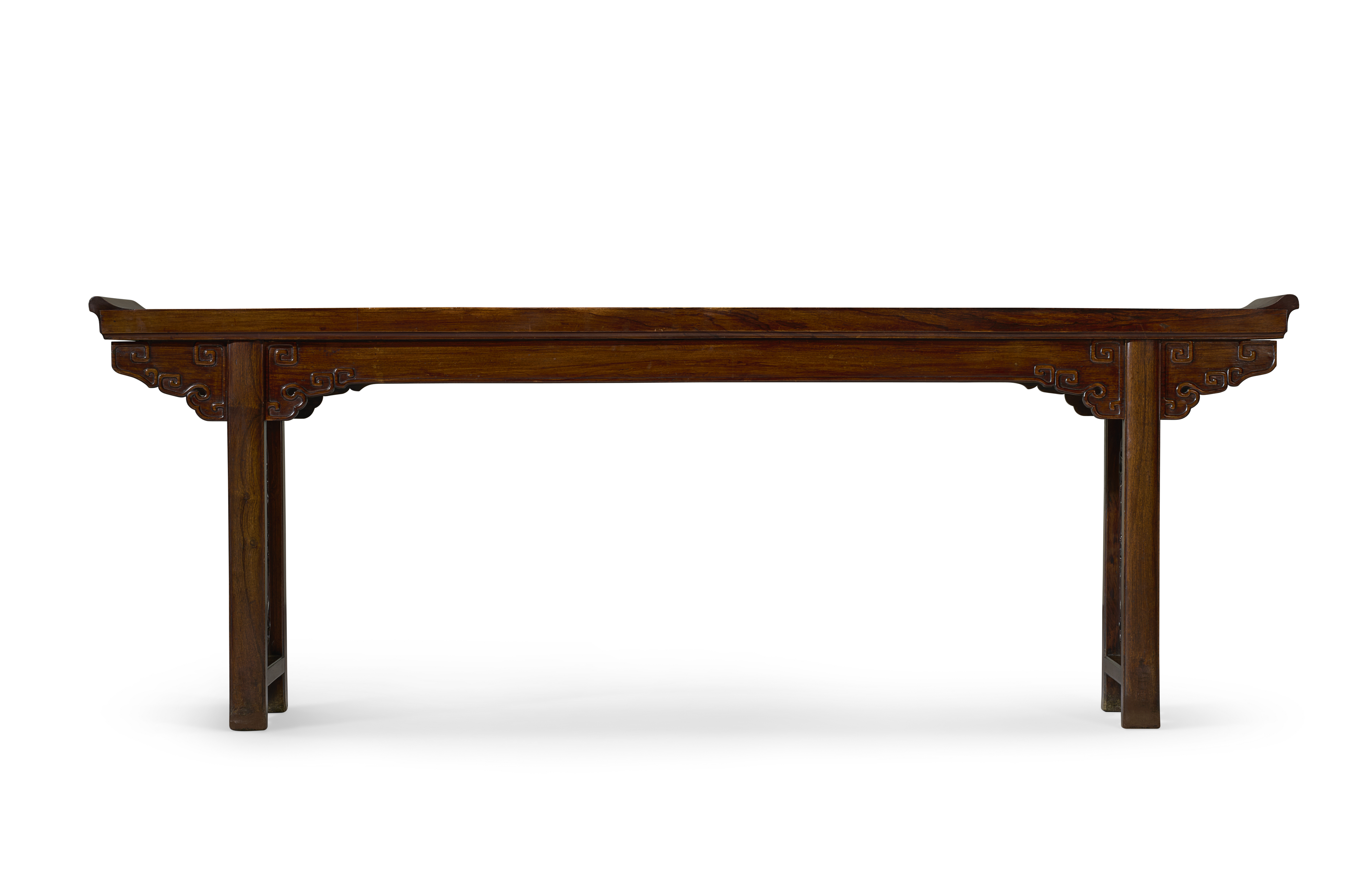 A long, rectangular wooden table with ornate legs and slightly curved ends.