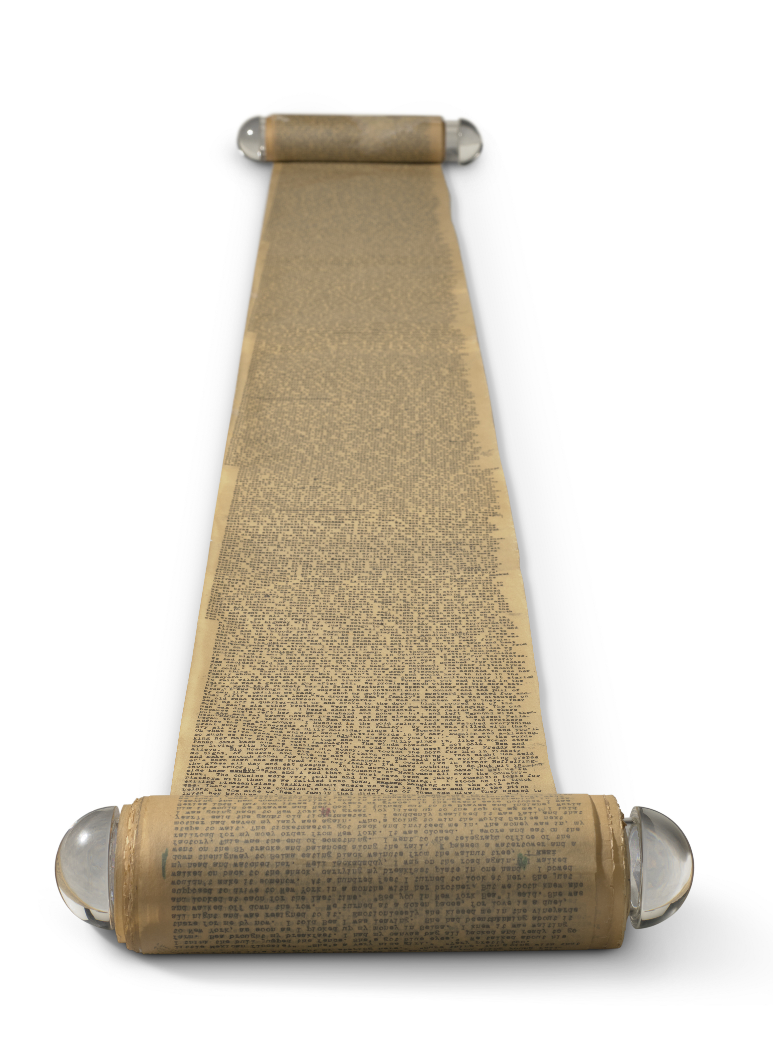 A long, vintage scroll covered densely with typewritten text is laid out on a white surface.