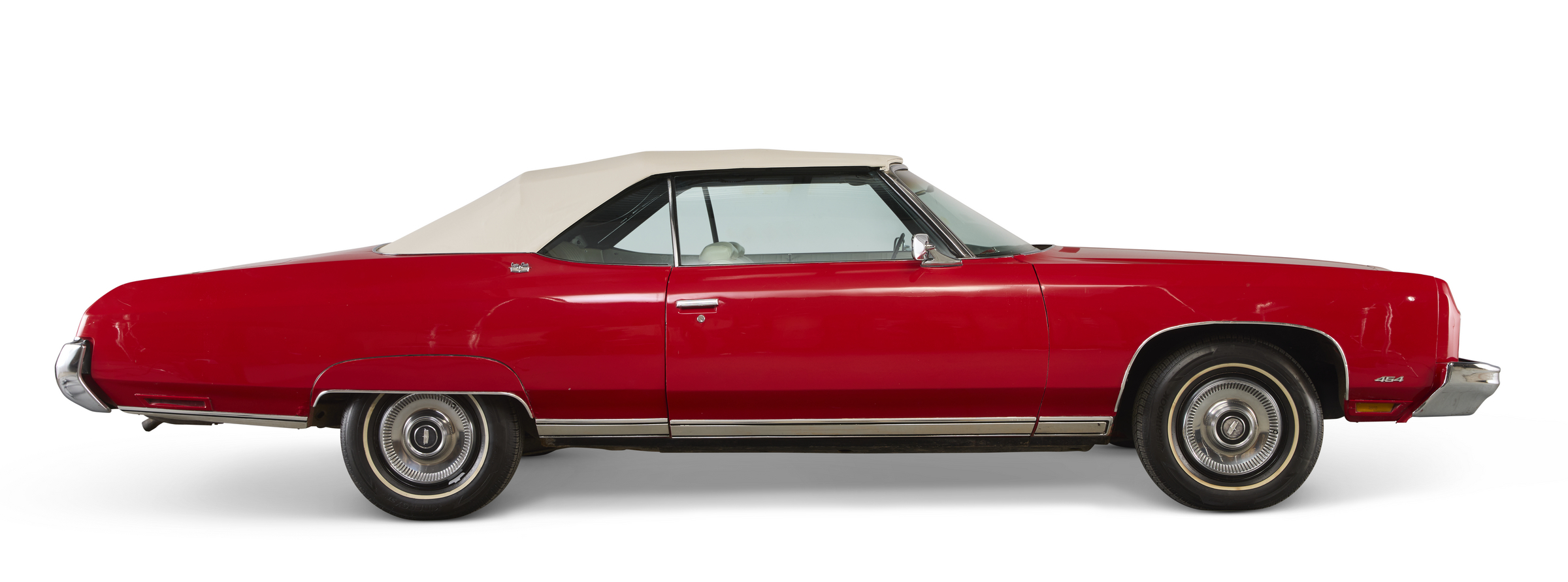 A classic red convertible car with a white soft top, viewed from the side.