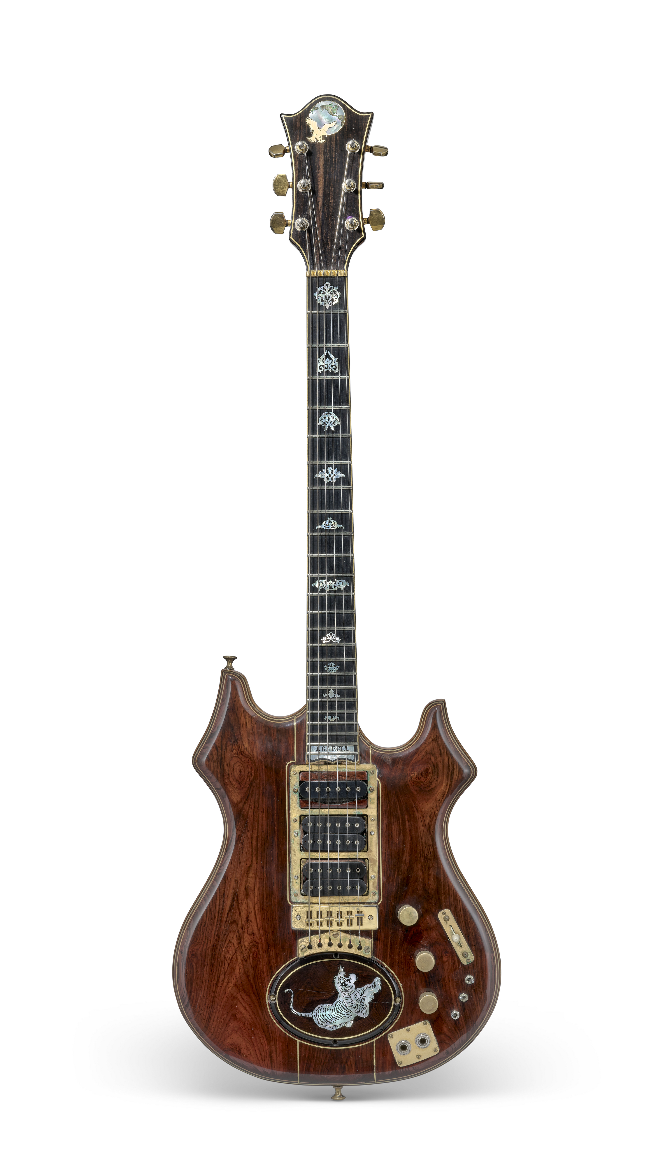 A custom electric guitar with ornate inlays, gold hardware, and a decorative body design.