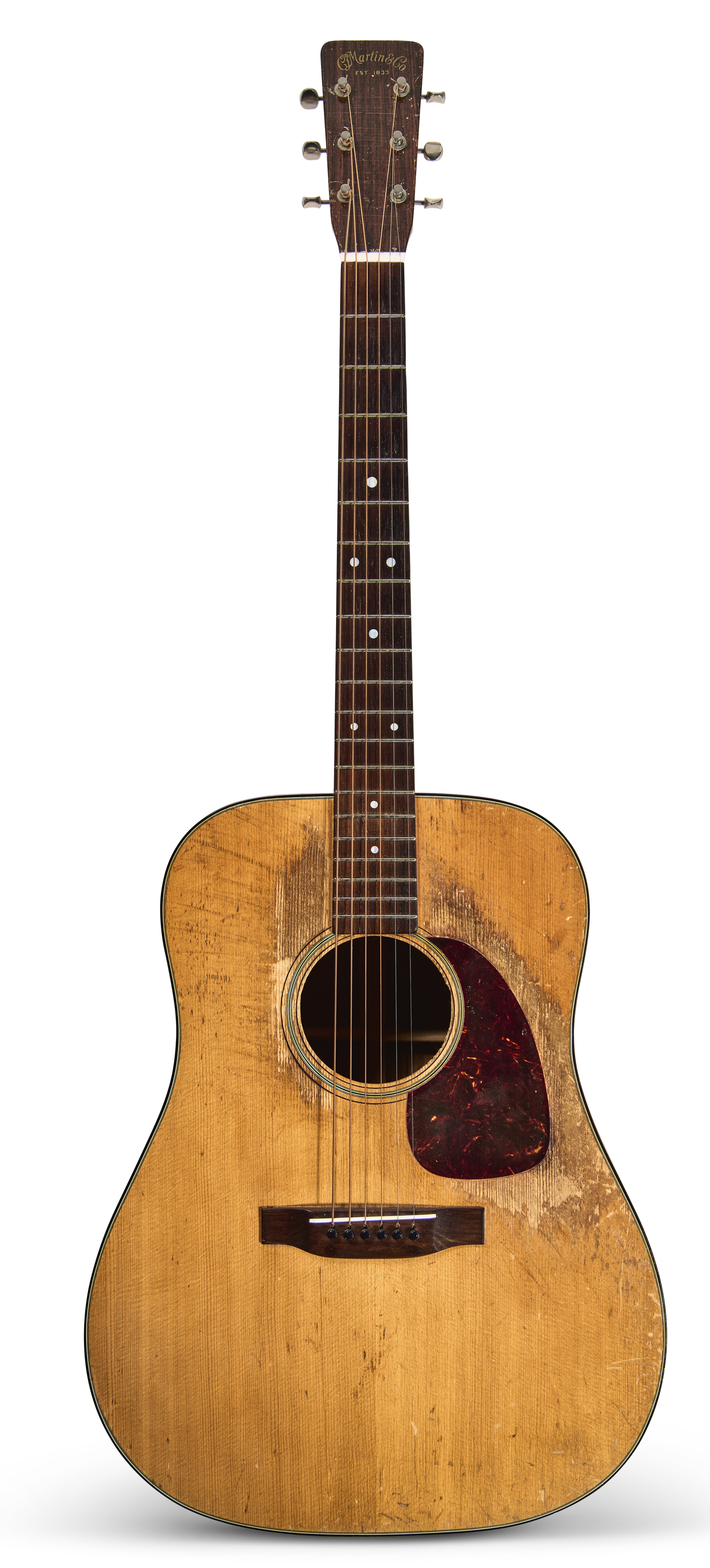 A worn acoustic guitar with a natural wood finish and a dark pickguard.