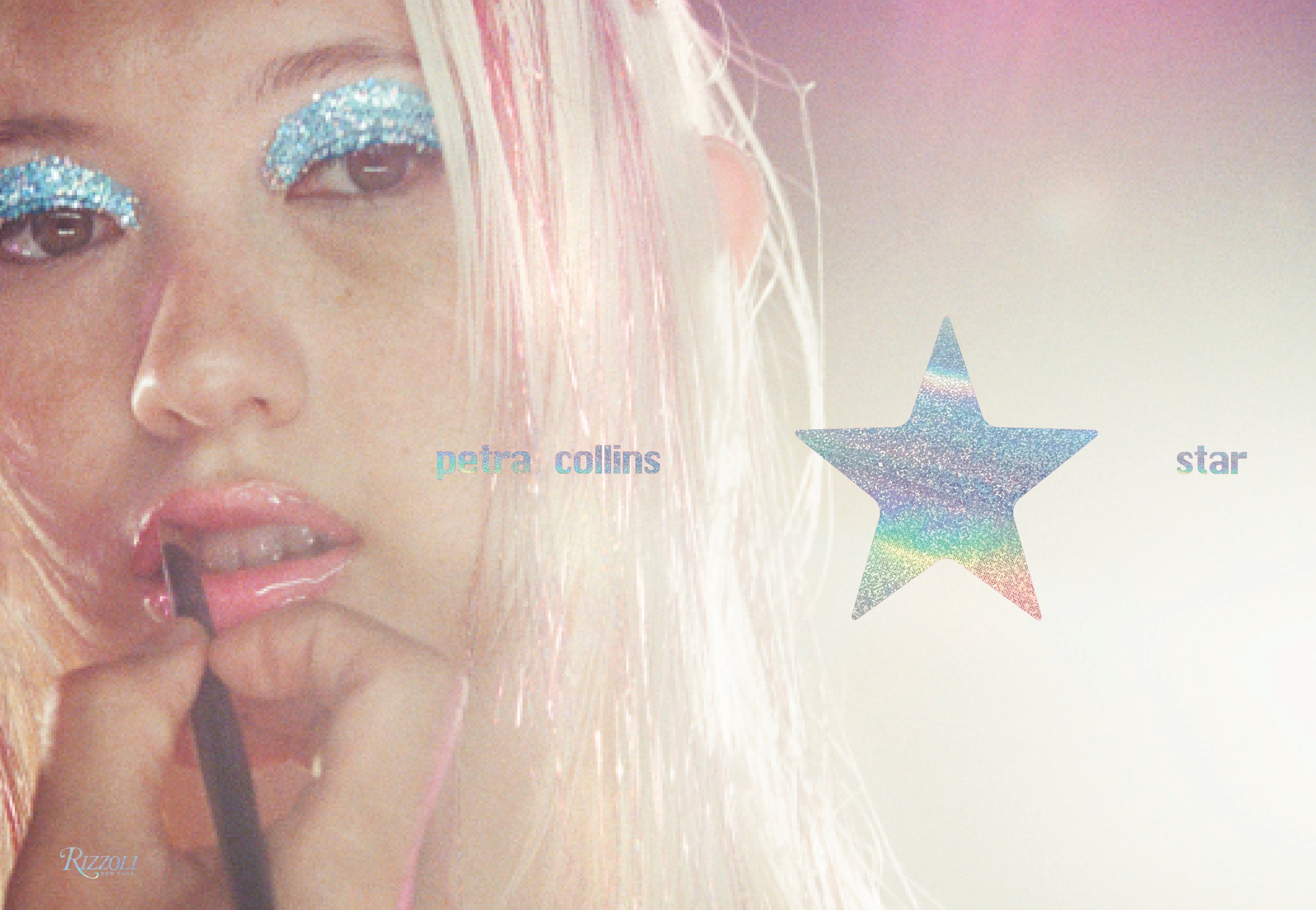 A close-up of a person with glittery blue eyeshadow, shiny pink lips, and a pastel star graphic.