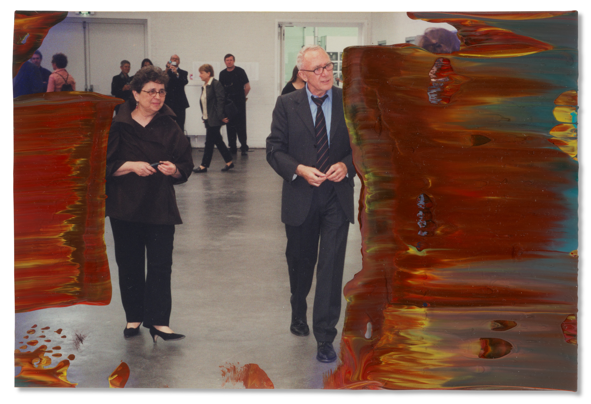 Two people walk in an art gallery, with colorful paint streaks covering the image's sides.