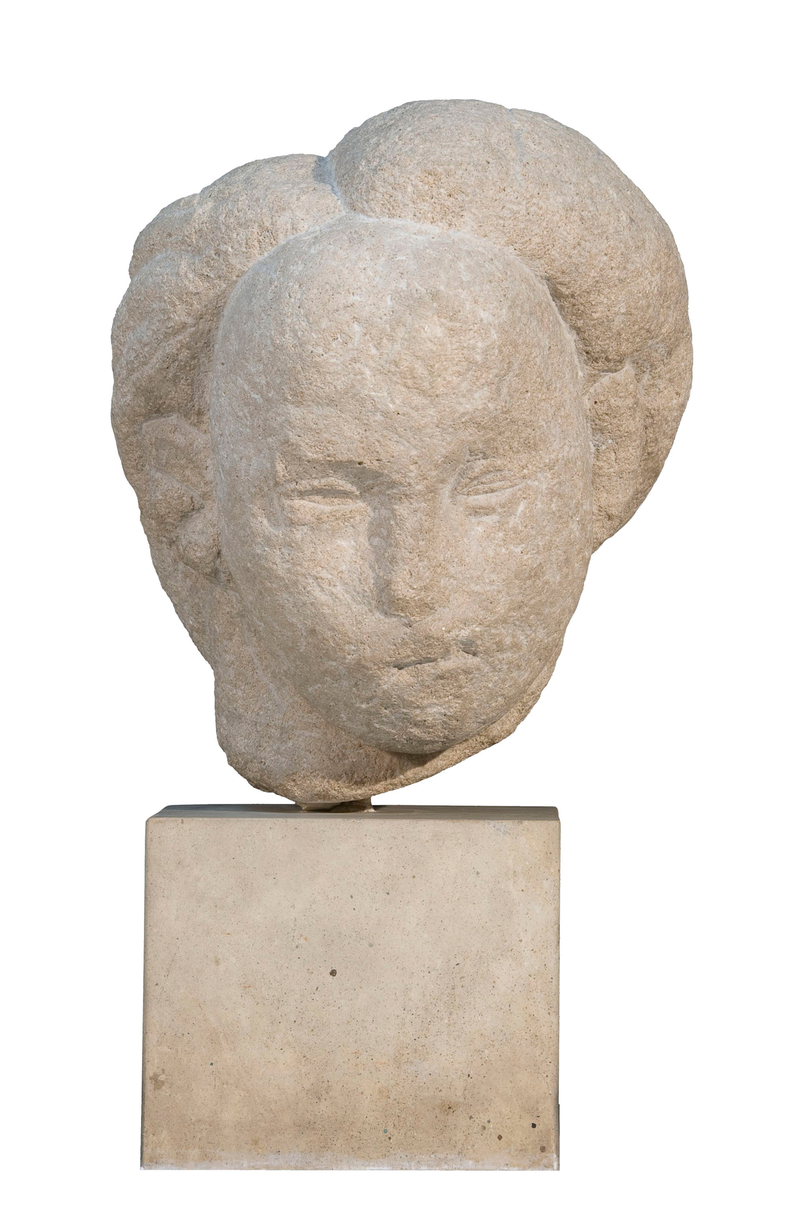 A stone sculpture with an abstract shape sits atop a rectangular base.