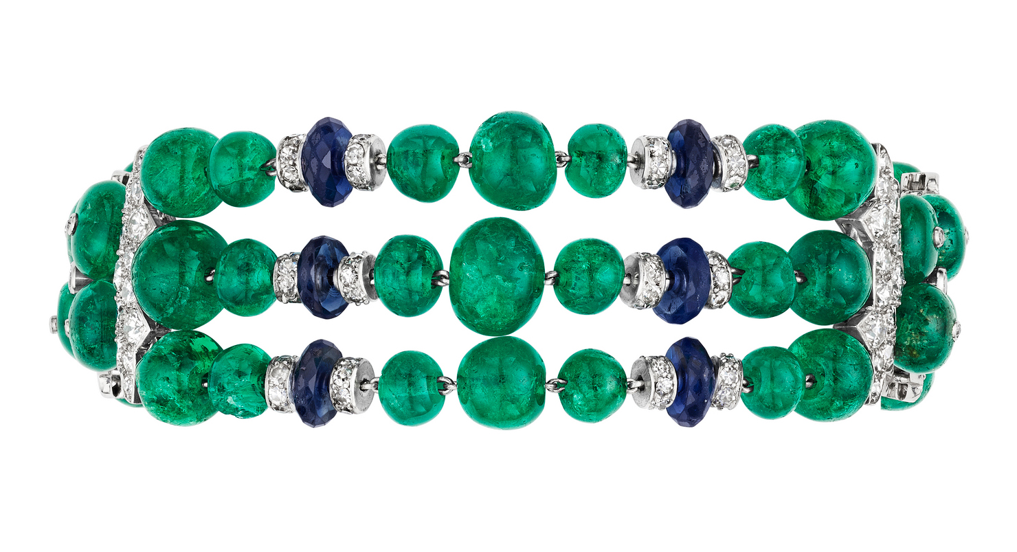 A beaded bracelet featuring green, blue, and silver round gemstones in three rows.