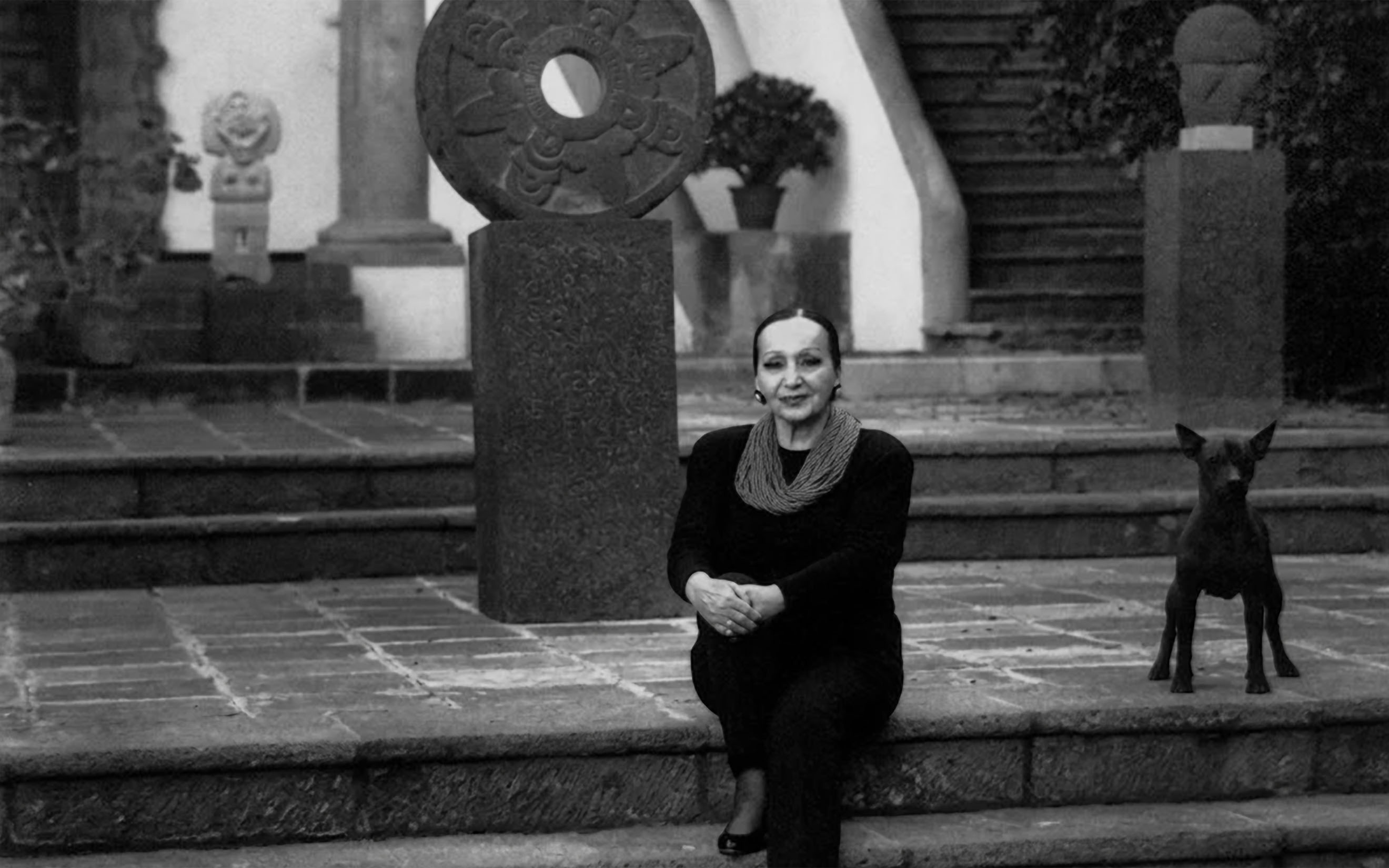 Dolores Olmedo with one of her beloved Xoloitzcuintle dogs in the orange tree courtyard at her home, Hacienda La Noria, which would later become the Dolores Olmedo Museum