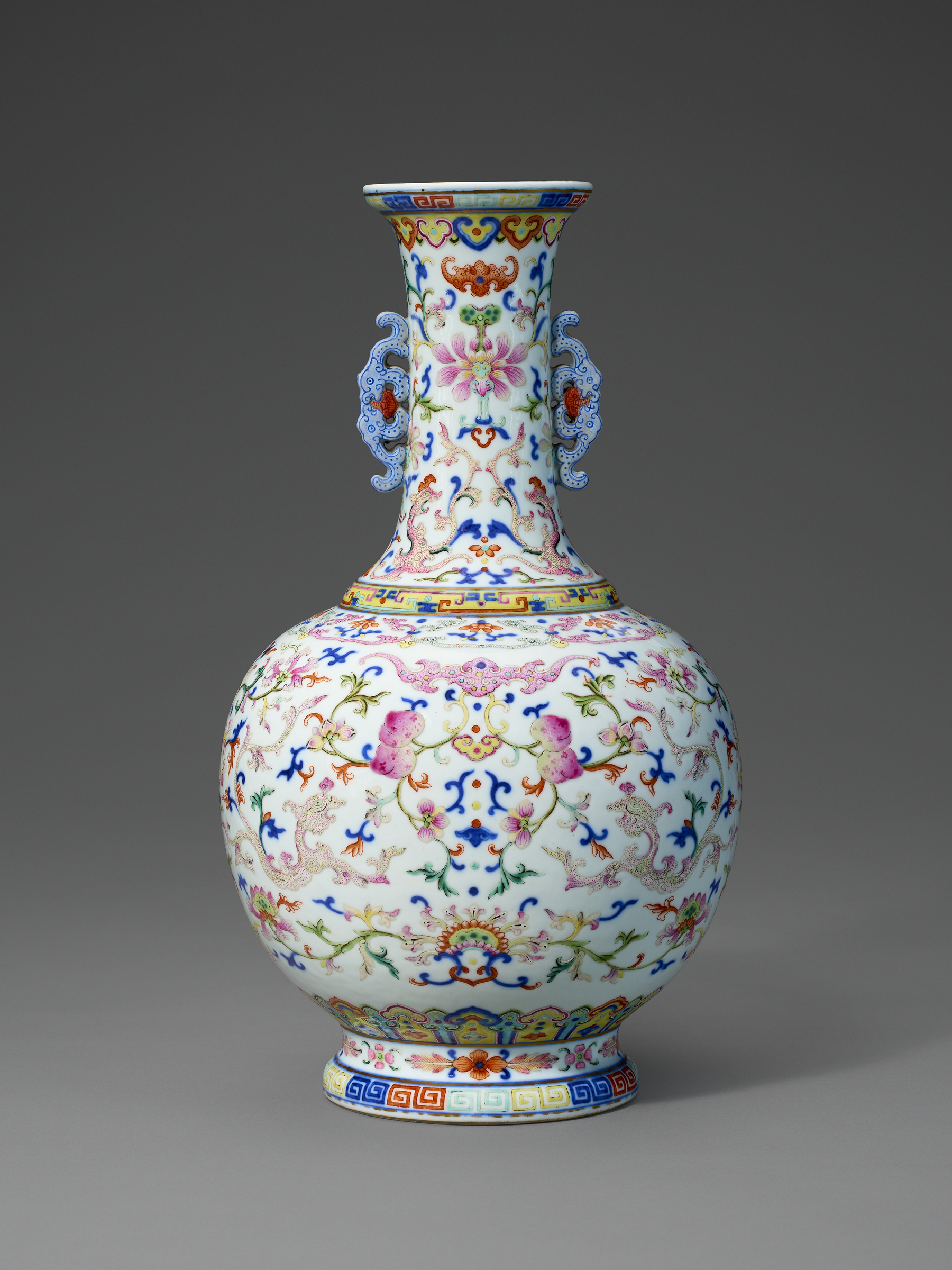 A colorful, ornate porcelain vase with floral and geometric patterns on a white background.