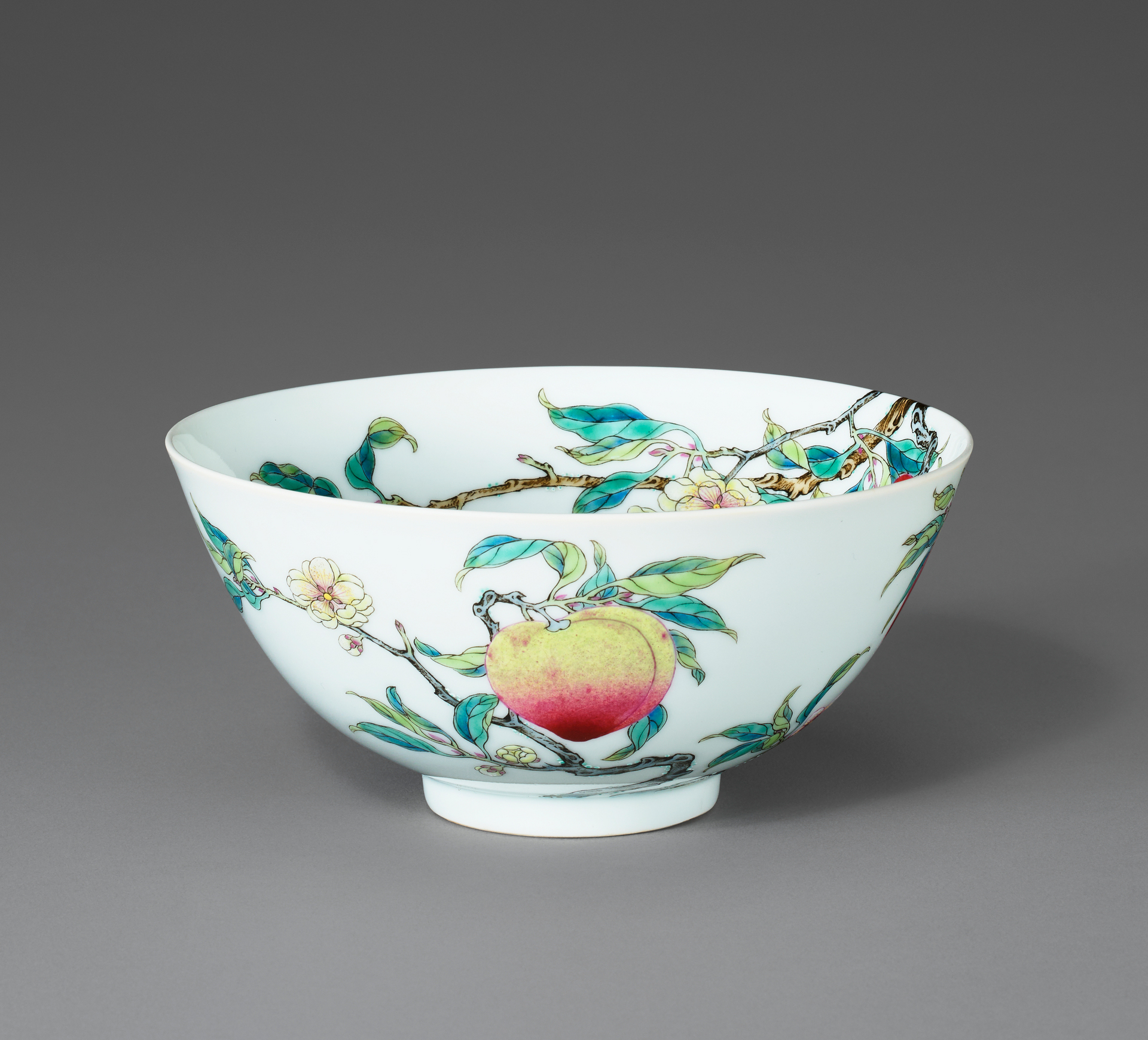 A white porcelain bowl decorated with colorful peach and floral designs.