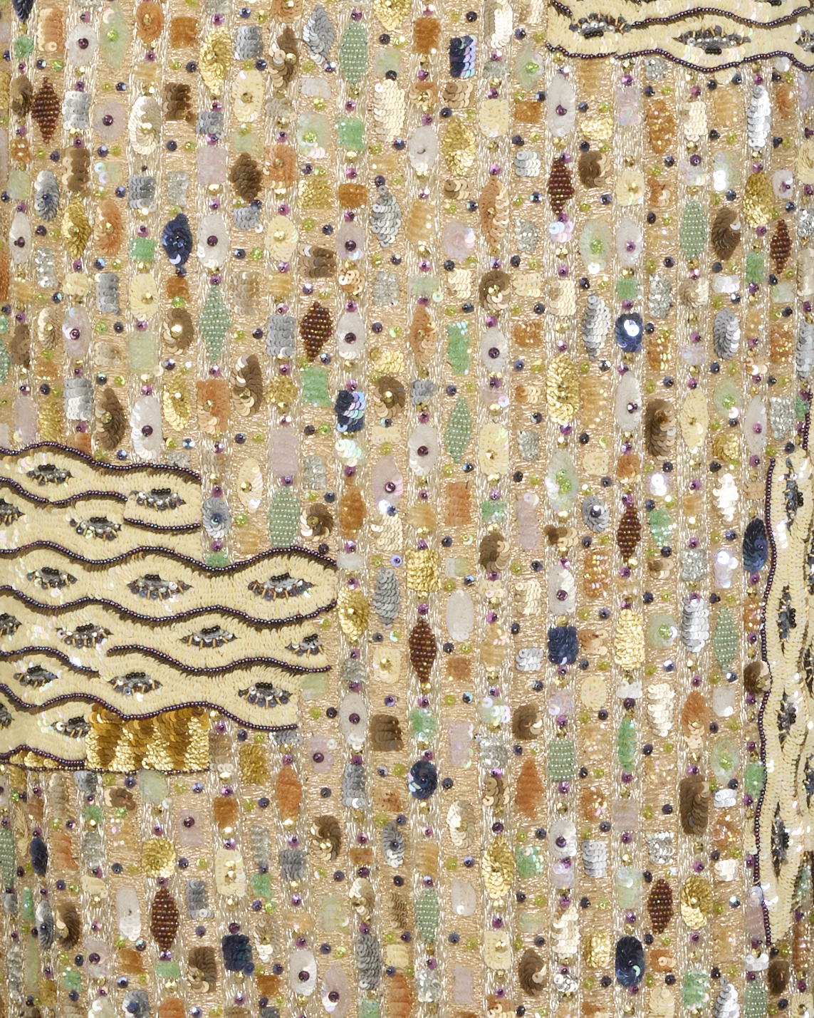 The image shows a close-up of a beaded and sequined textile with wavy embroidered patterns.