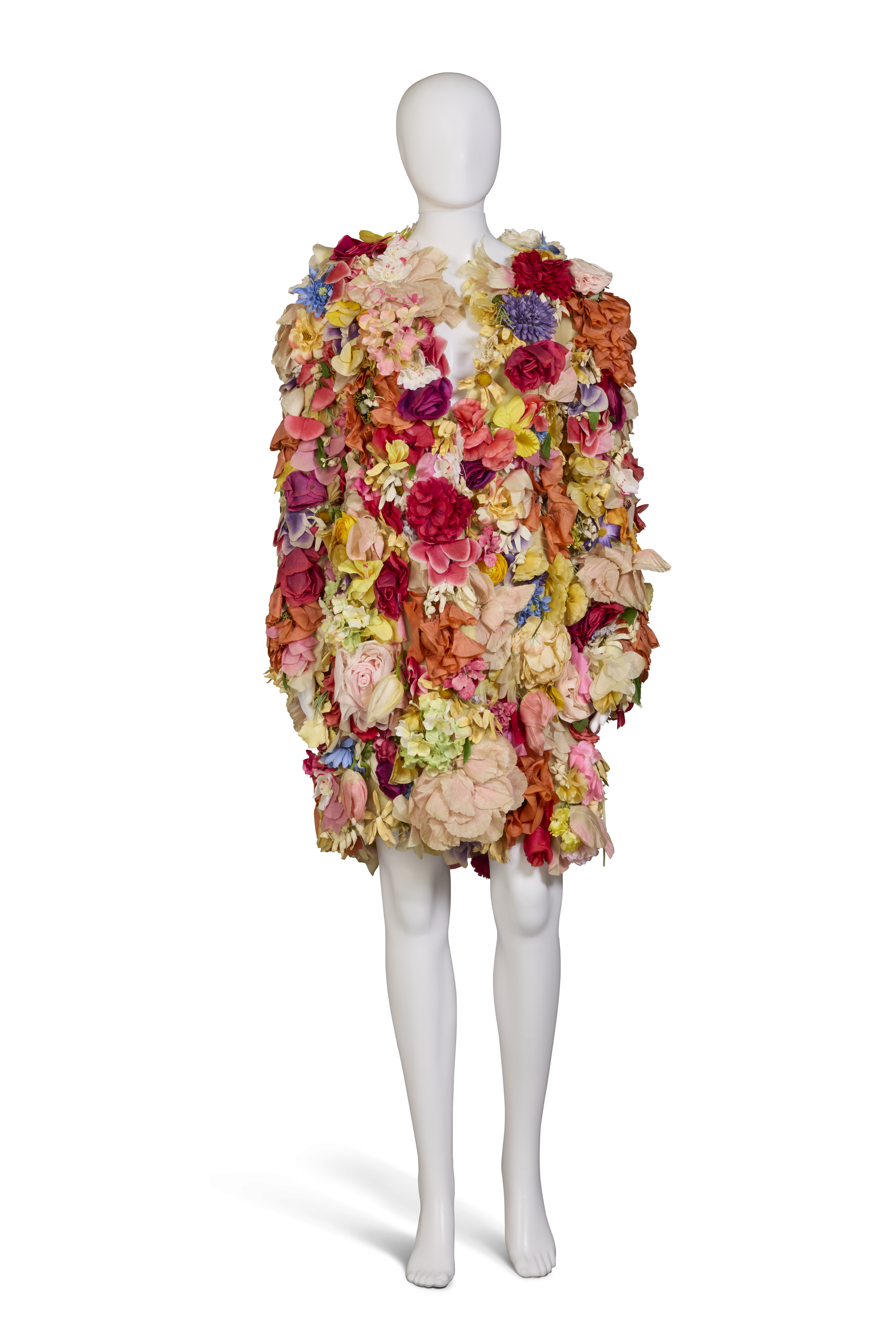A mannequin wears a colorful dress covered entirely in large artificial flowers.