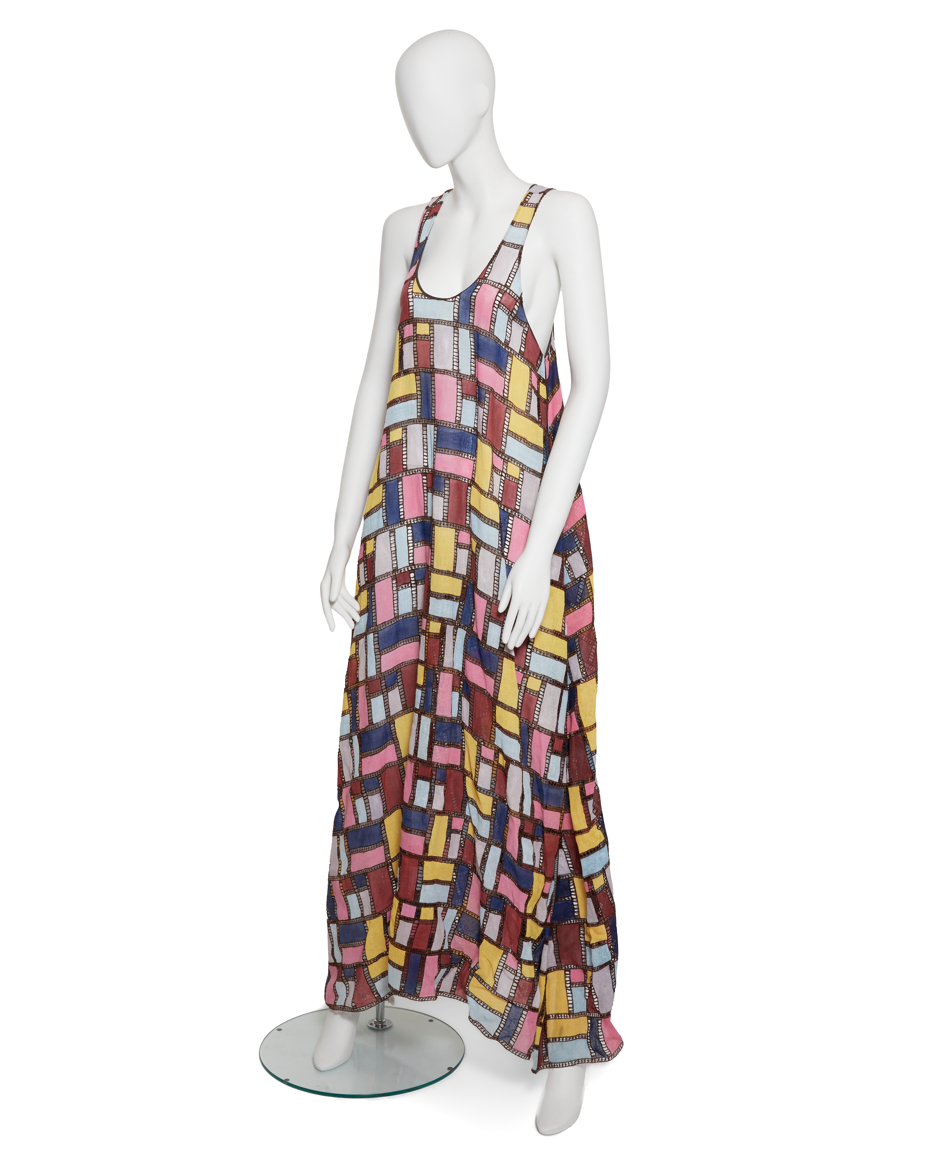 A mannequin wears a colorful, geometric-patterned sleeveless maxi dress.