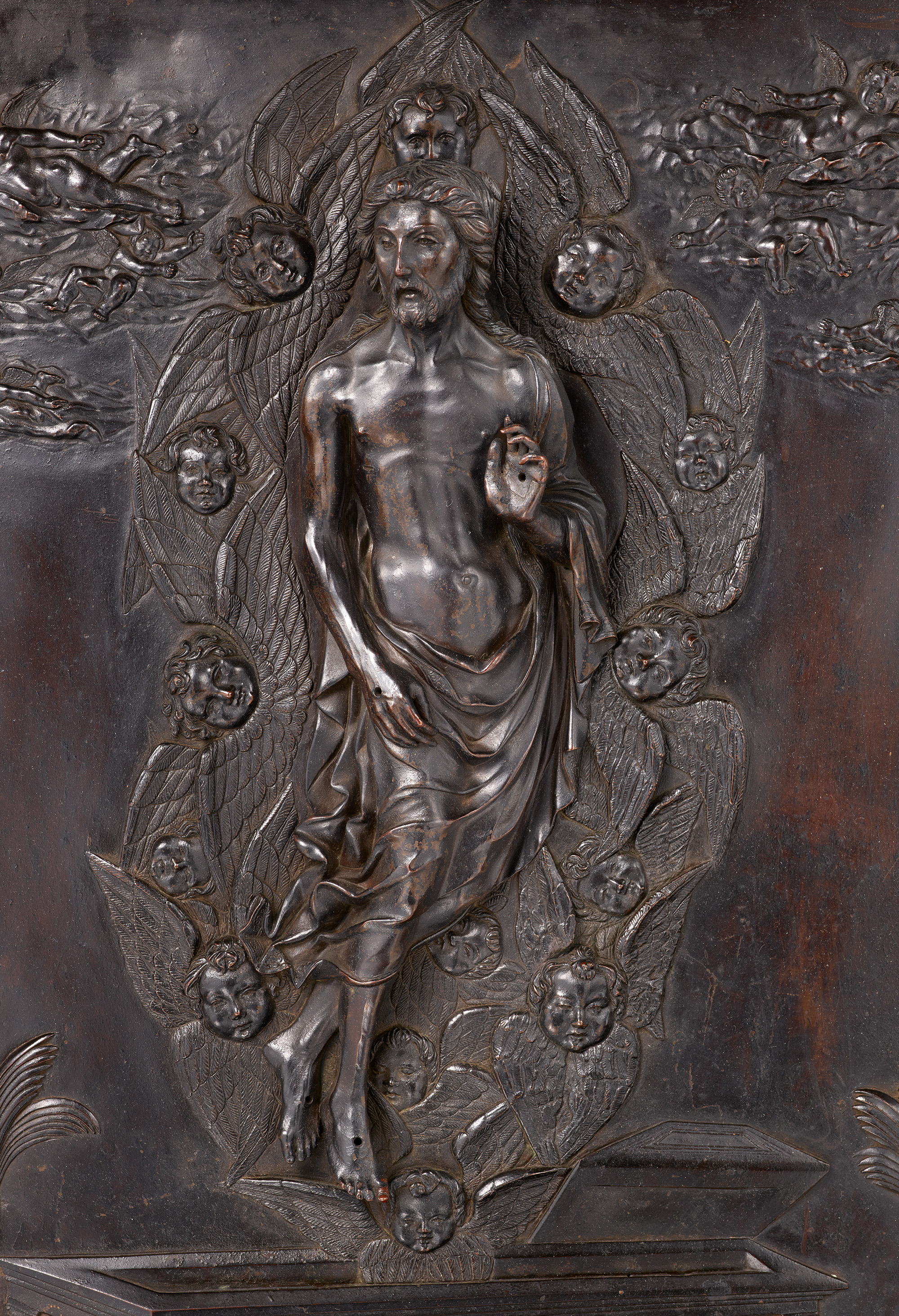 A detailed relief sculpture depicts Christ surrounded by angels, ascending or appearing glorified.