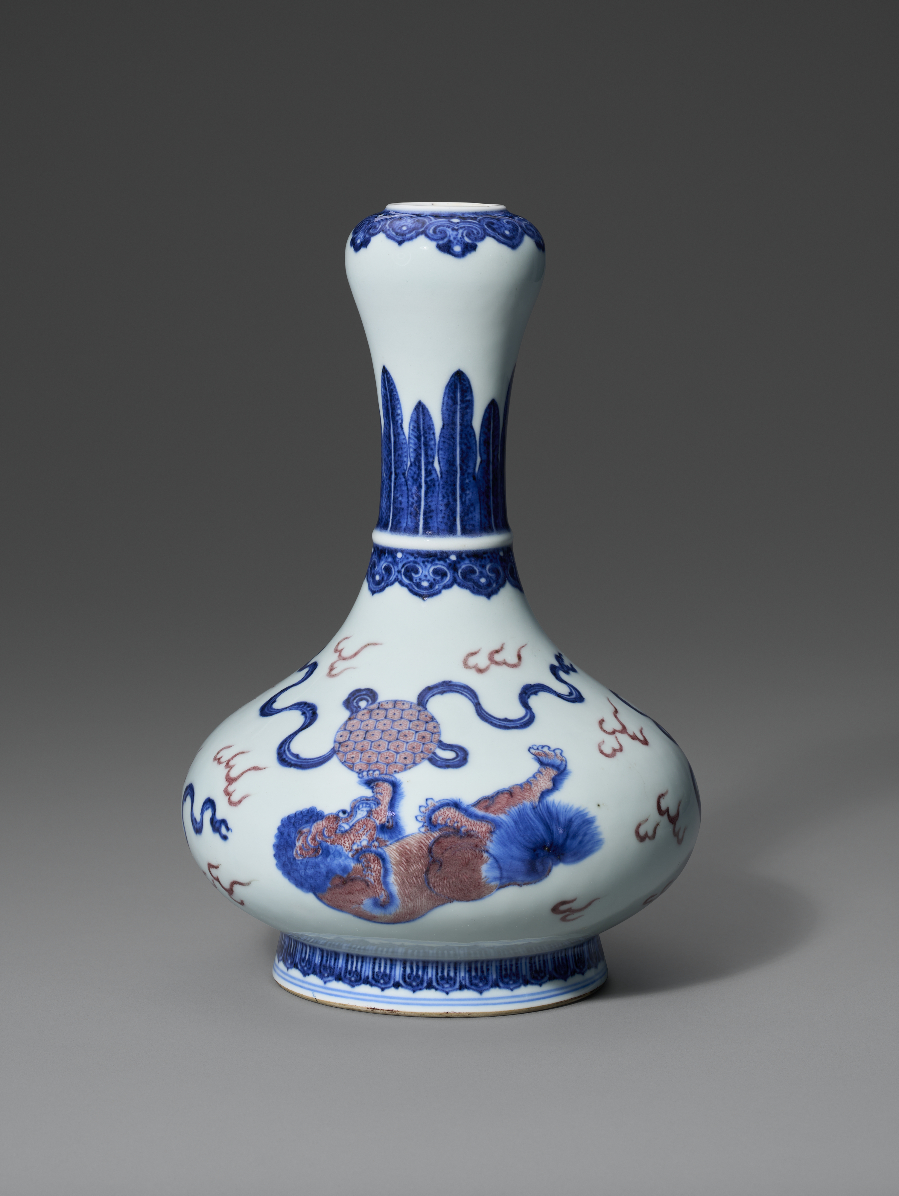 A porcelain vase with blue and red designs featuring a mythical creature and floral patterns.
