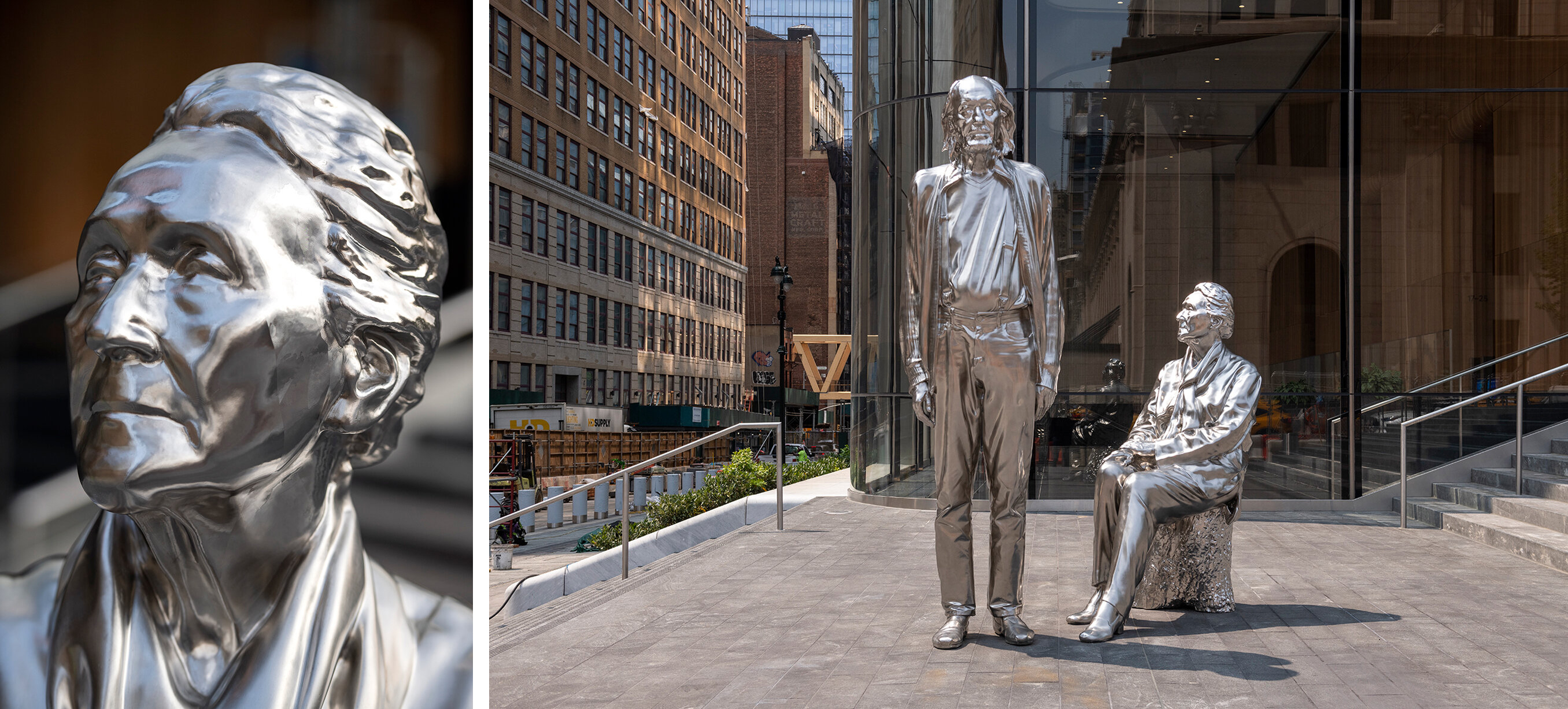 Two shiny silver statues of people are displayed outside a modern city building.