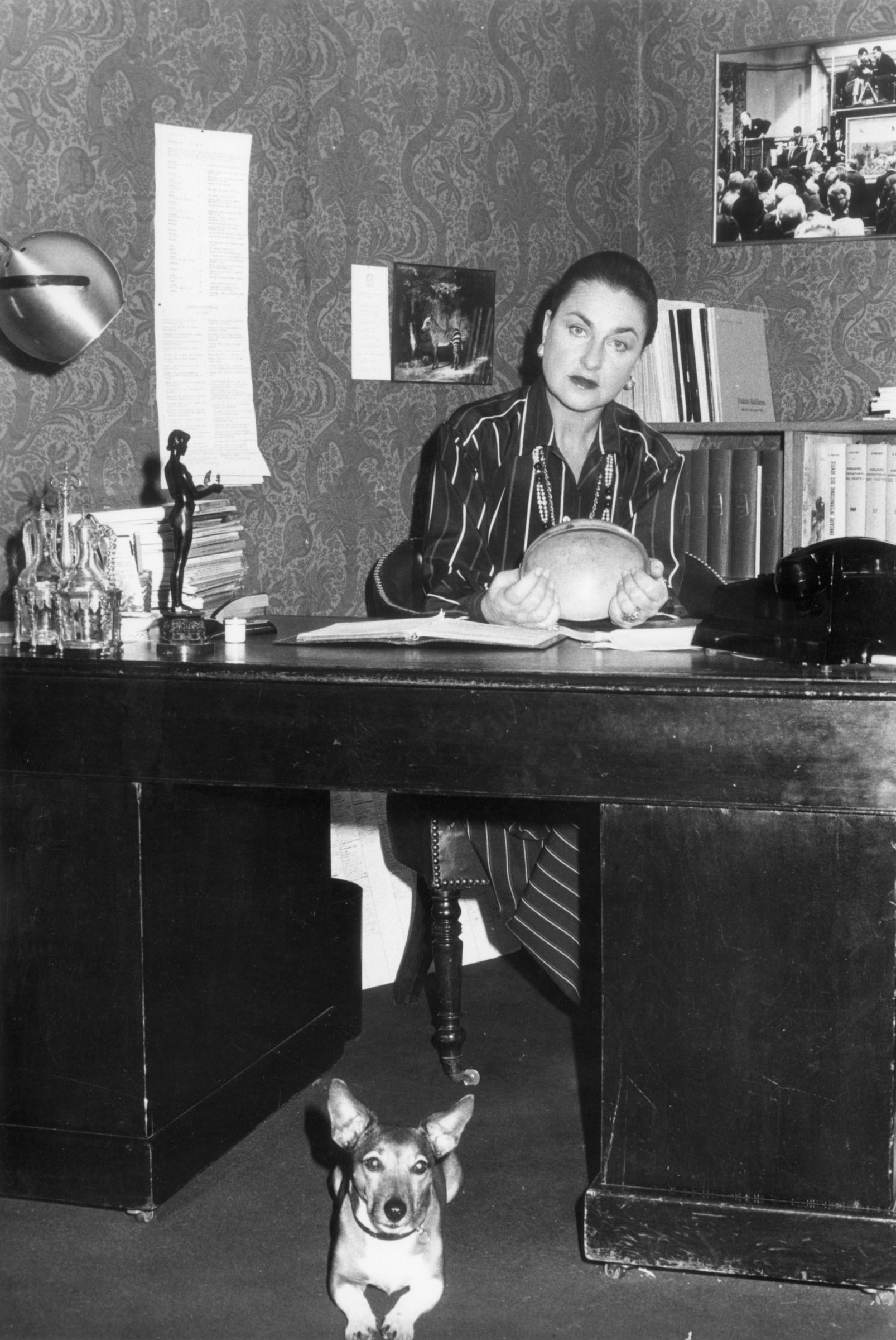 Jeanne-Marie de Broglie at her desk, with her beloved dog Seraphine on the floor below. Seraphine was immortalised by Diego Giacometti in a 'Berceau' coffee table he created for de Broglie around 1981