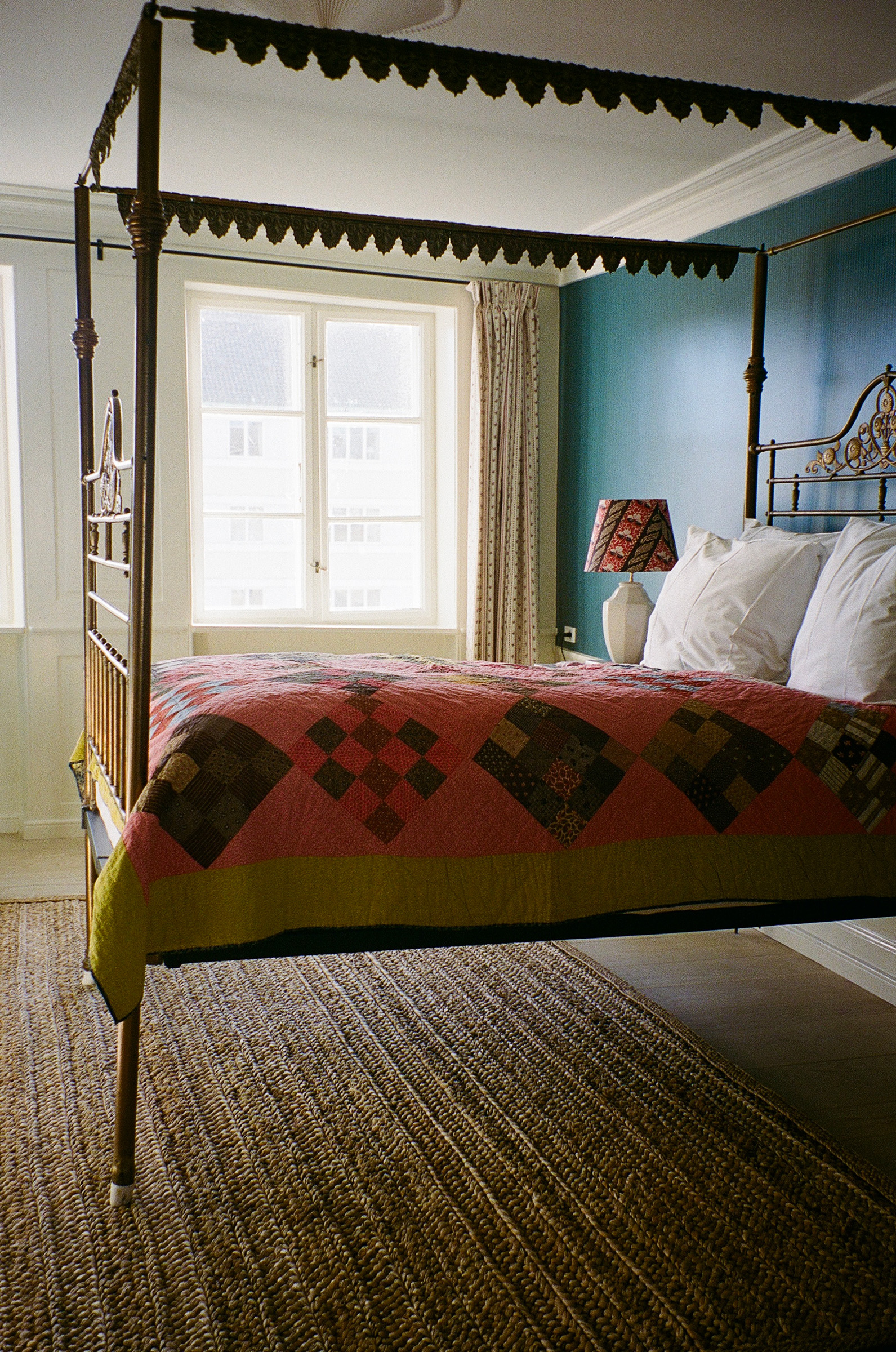 At The Apartment, Copenhagen: the antique bed, adorned with an antique American patchwork quilt, came from a friend who said she no longer had room for it
