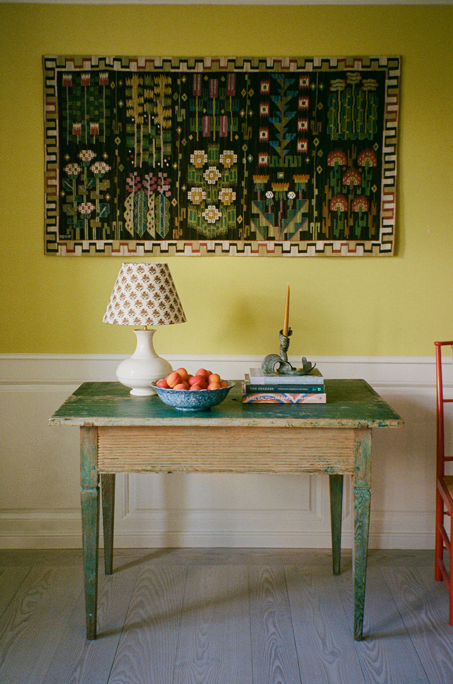 On the 18th-century Swedish pine table is a French lamp with a customised shade in Namay Samay fabric by The Apartment, a candlestick by Griegst and a terre melee bowl of apricots. Above is Marta Maas-Fjetterstrom’s hand-woven 'June flowers' wall hanging