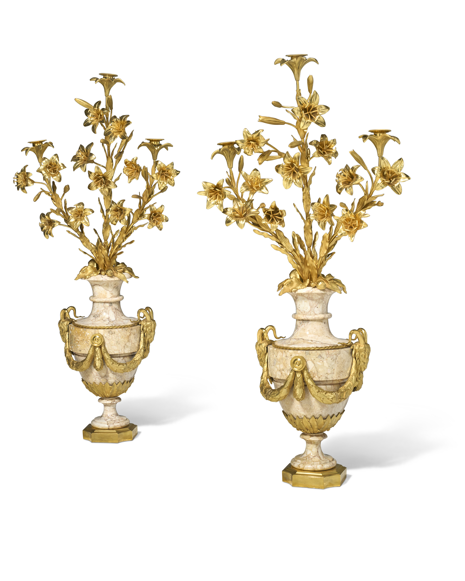 A pair of ornate marble and gold vases with decorative golden floral arrangements.