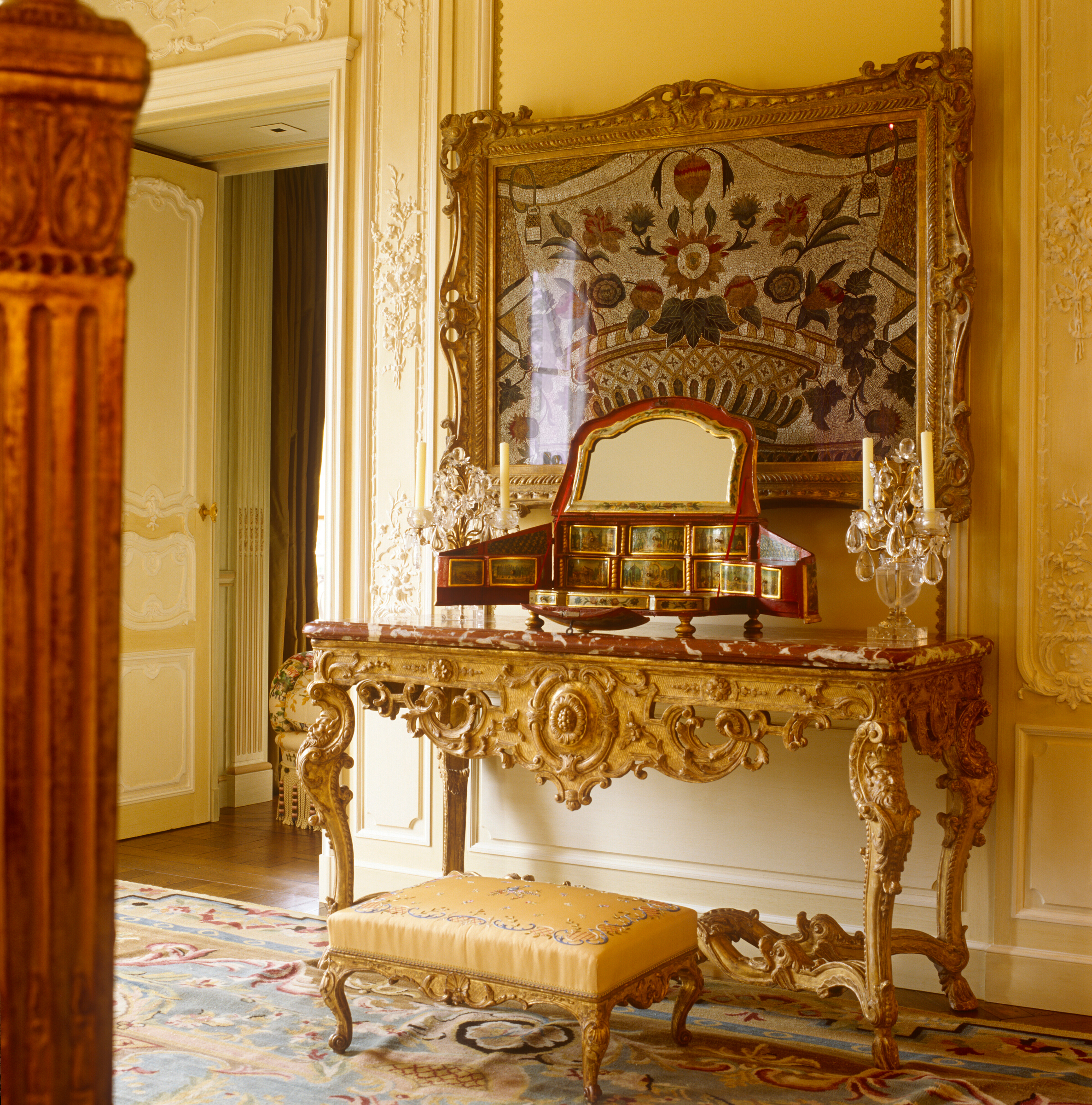 Elegant ornate vanity table with mirrors, gold details, and matching upholstered stool.