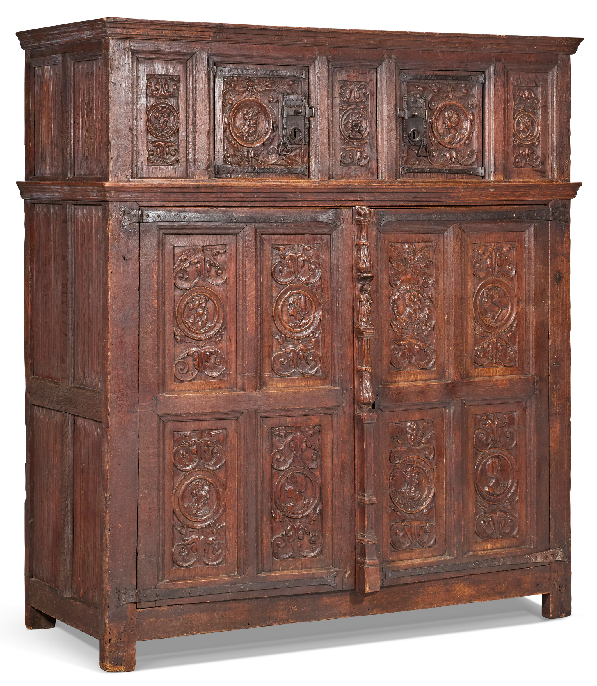 A large, ornate antique wooden cabinet with intricate carved panel designs and metal locks.