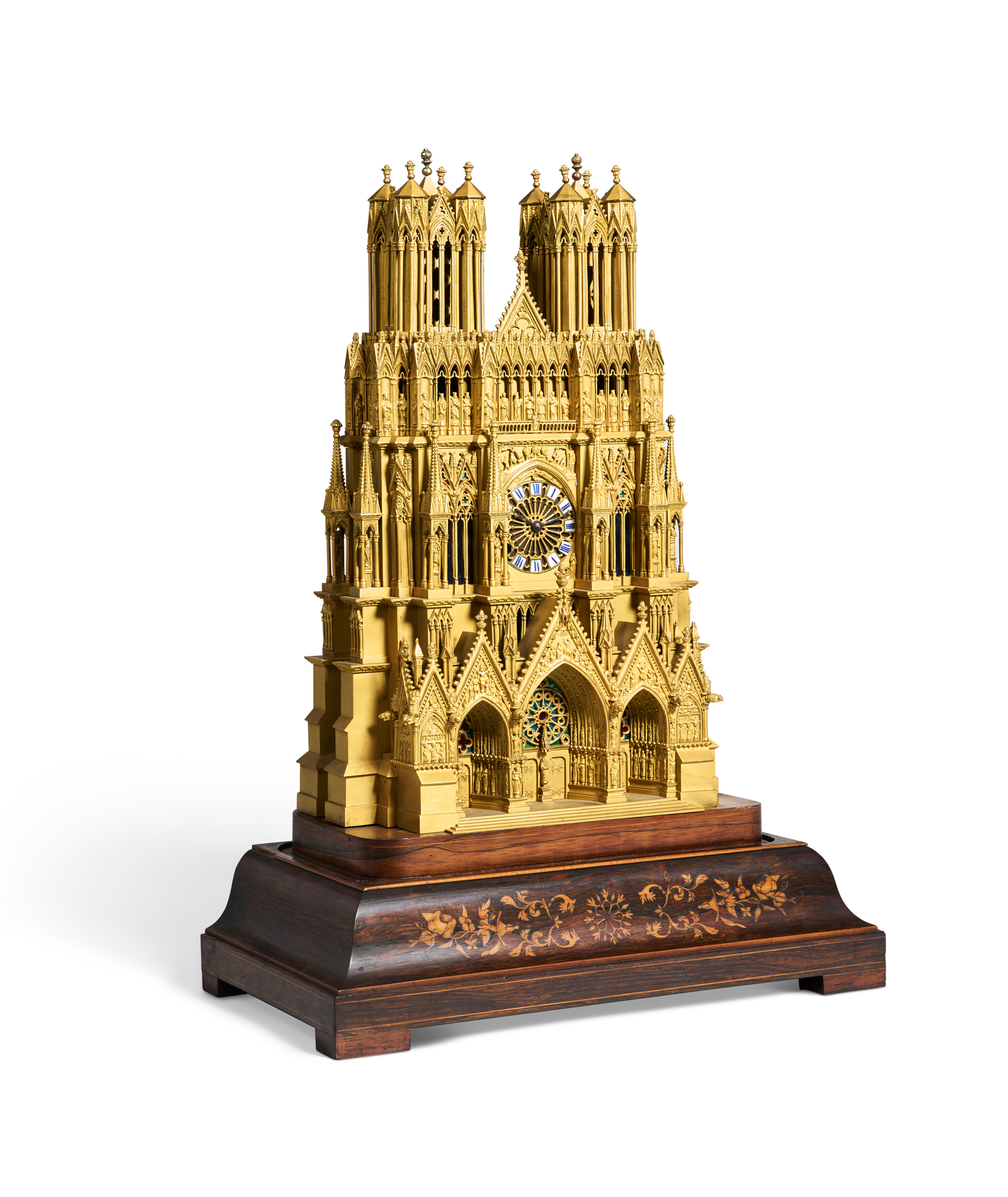 A detailed golden cathedral model clock sits on a wooden base with floral inlay designs.