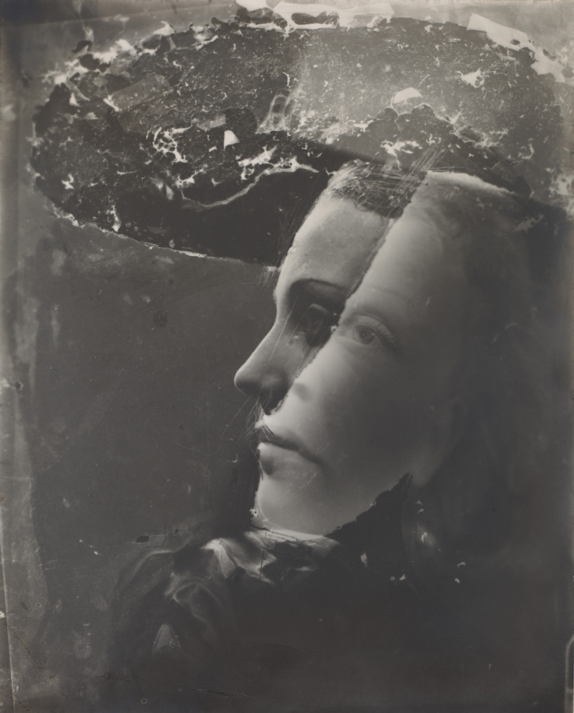A double-exposed black and white photograph shows a woman's profile overlapping another portrait.