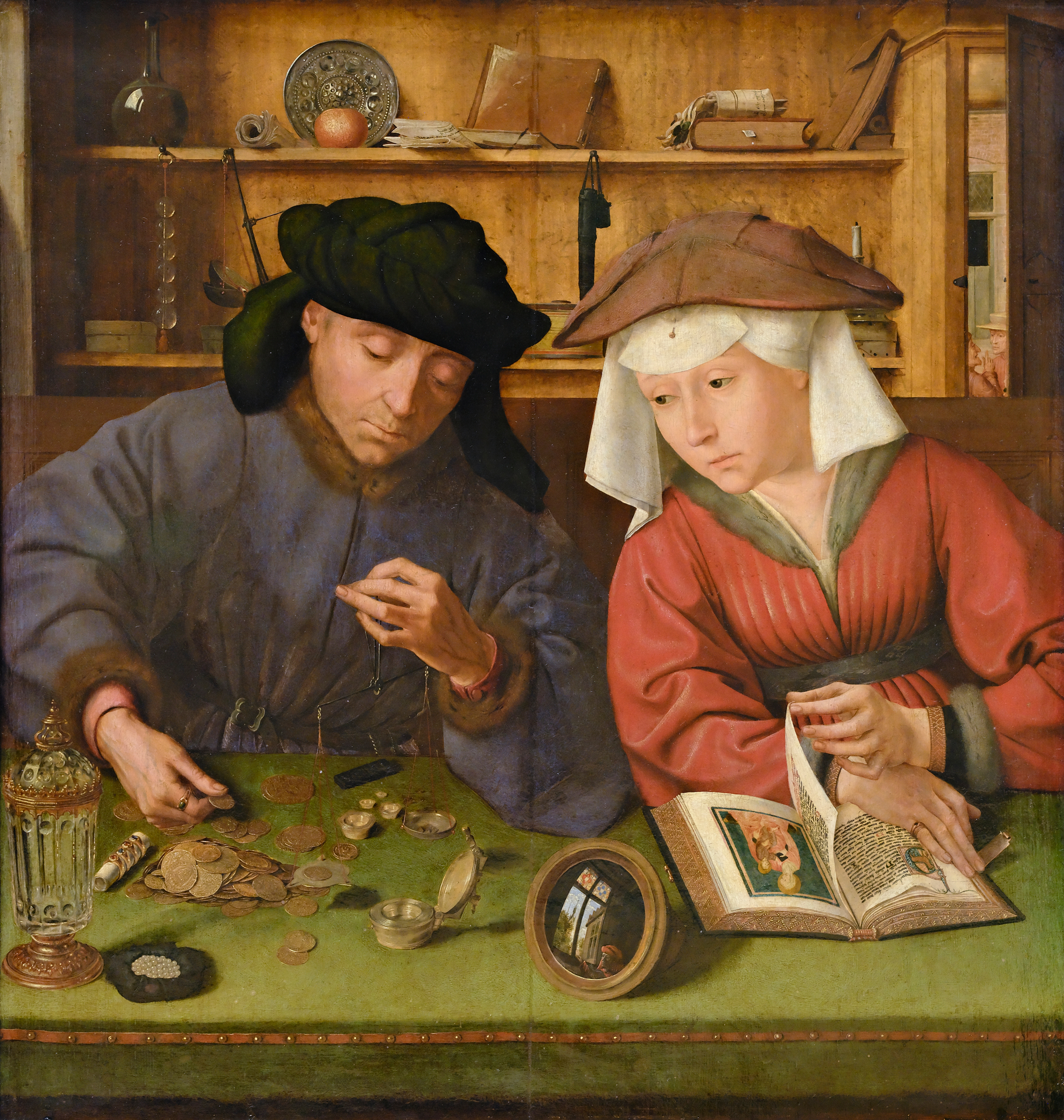 A man and woman sit at a table counting coins, with various items and an open book beside them.