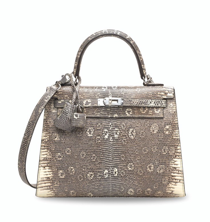A luxury handbag made of textured, patterned leather with a handle and shoulder strap.